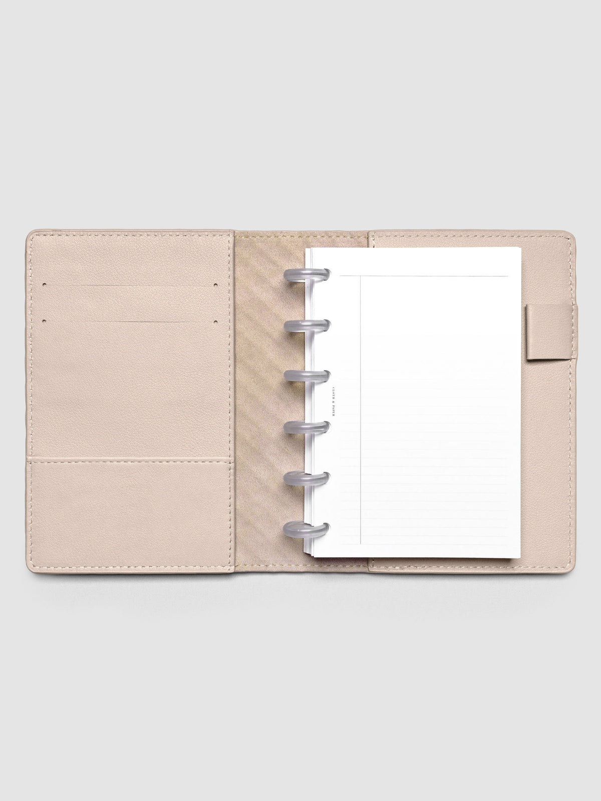 Open beige leather planner folio with a CP petite discbound planner inside.