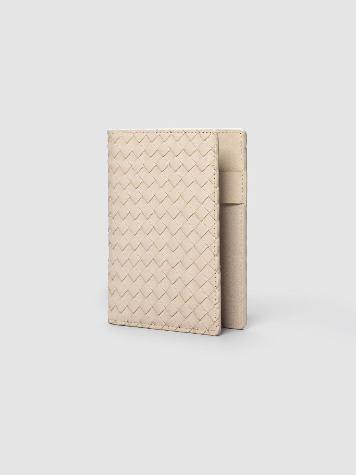 Beige woven leather planner cover shown standing at an angle.