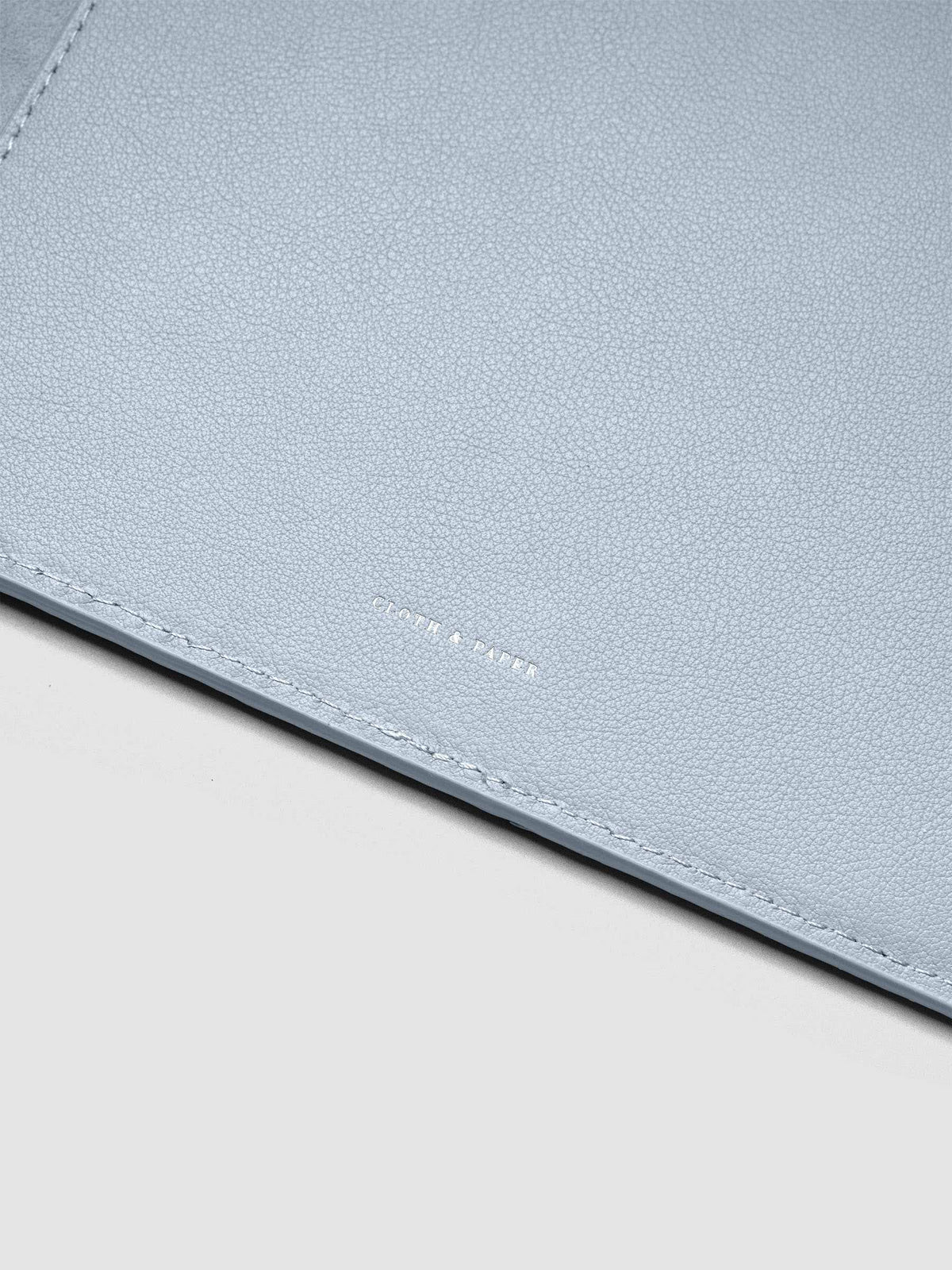 Close up of the foil Cloth & paper logo on the interior of a blue leather planner folio cover.