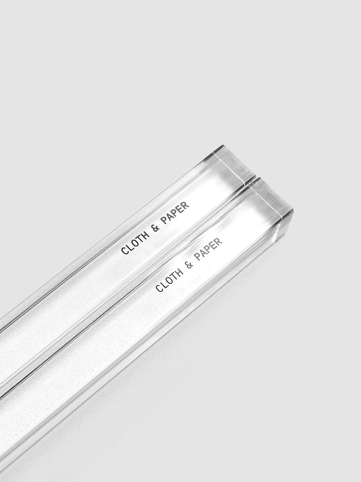 Stamp Sticks | Set of 2 shown from the squared top ends, two clear shafts running diagonally across a light gray background with the Cloth & Paper name printed in black