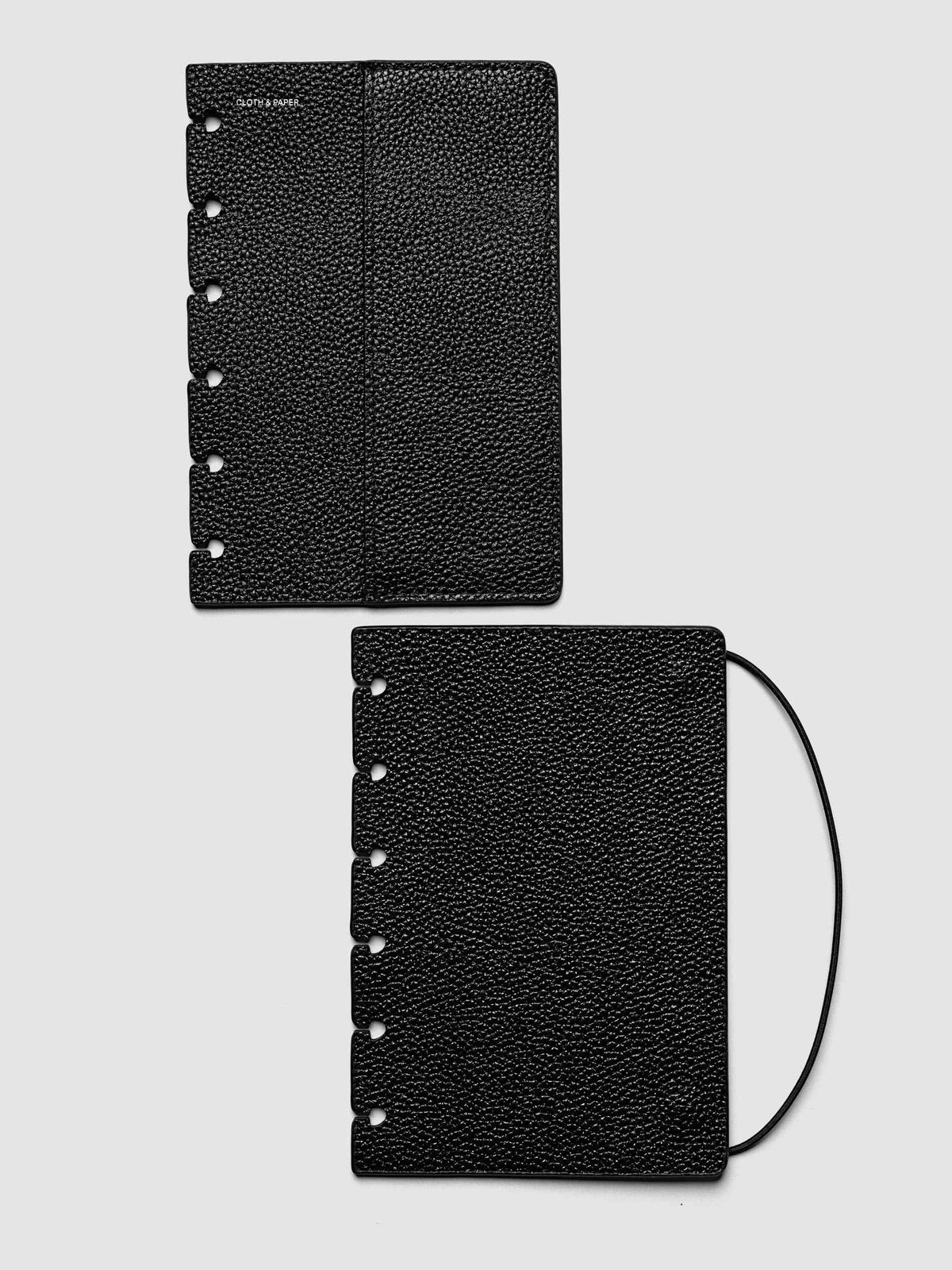 Both covers of the CP Petite 6-Disc Punch Genuine Leather Planner Cover Set laid flat side by side, the front cover with its sewn pocket seam and the back cover with the bungee cord looping out from the edge