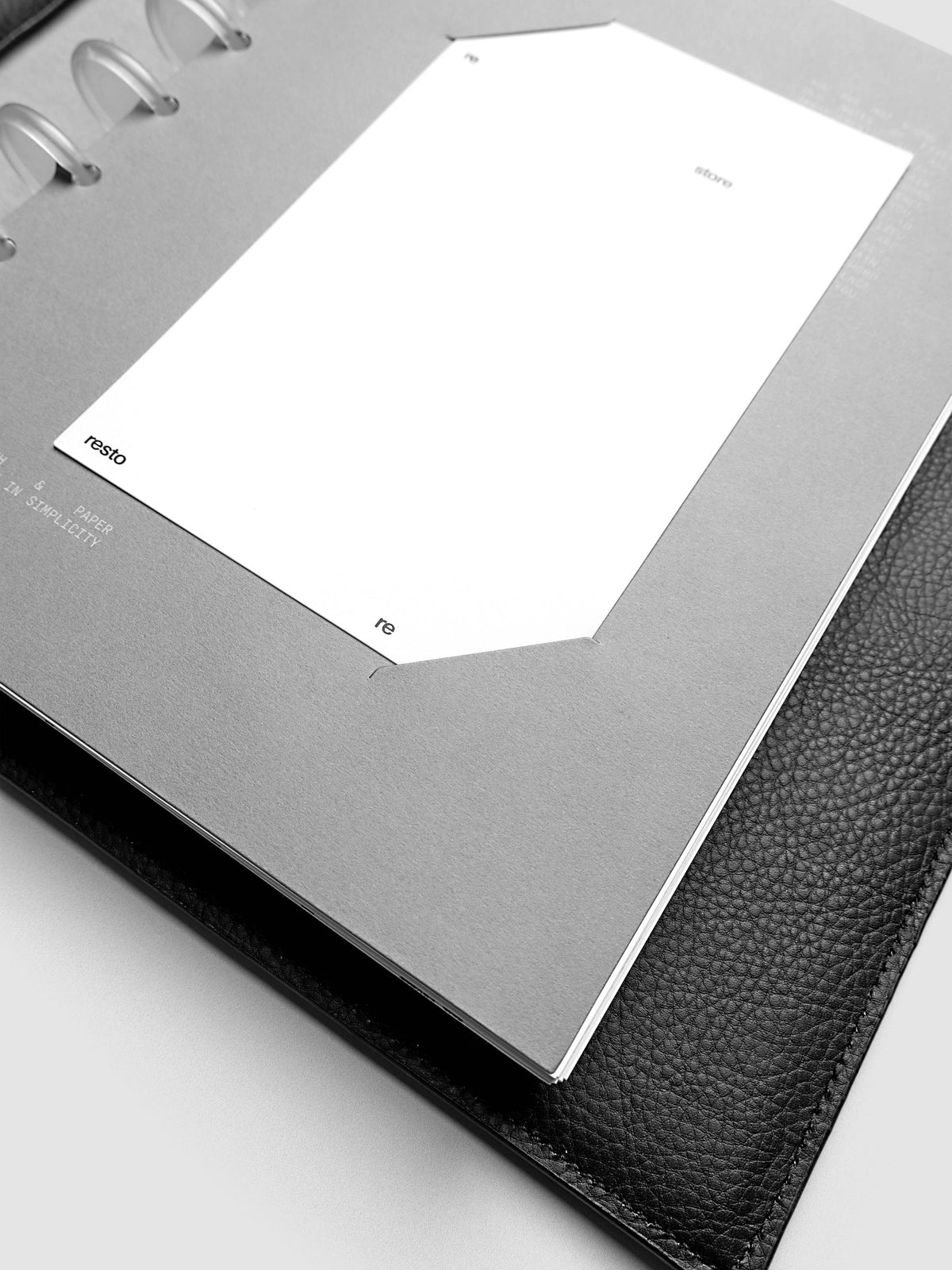 Close up view of a grey cardstock planner dashboard with white plastic card inserted in slits with white printed text.