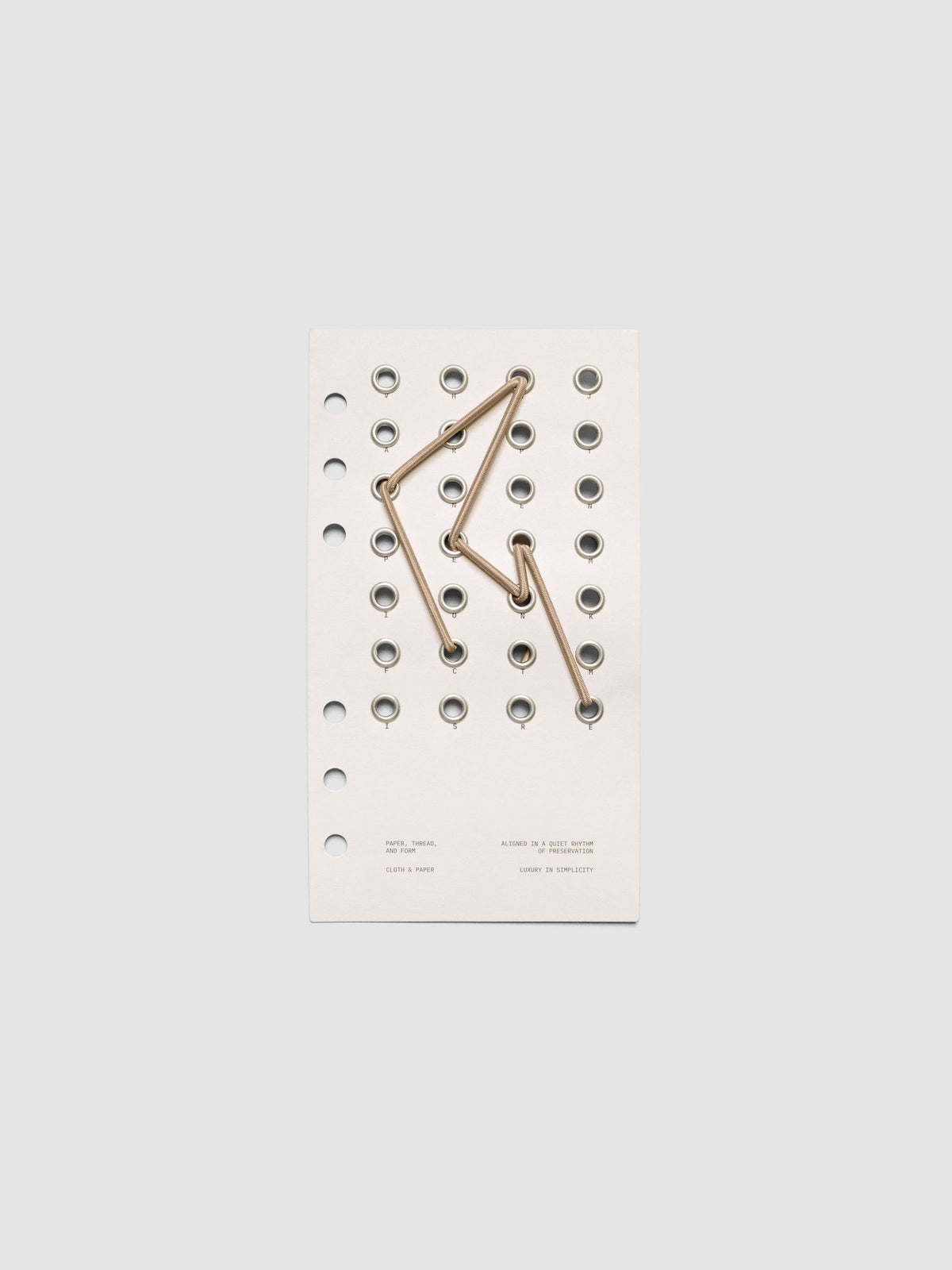 Cadence Dashboard with grommets and string on beige cardstock shown in size Personal for 6-ring planners and notebooks.