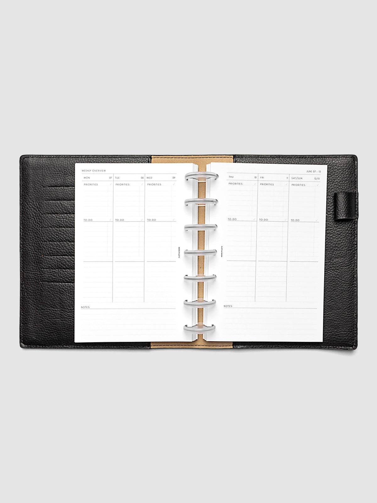 Both pages inside planner: 2027 Dated Weekly Task Planner Inserts, Monday Start, HP Mini 7-Disc Punch, full week-on-two-pages spread showing blank vertical columns for each day with labeled priorities, to-do, and notes sections, Saturday and Sunday combined, and weekly notes section along the bottom, shown inside a planner