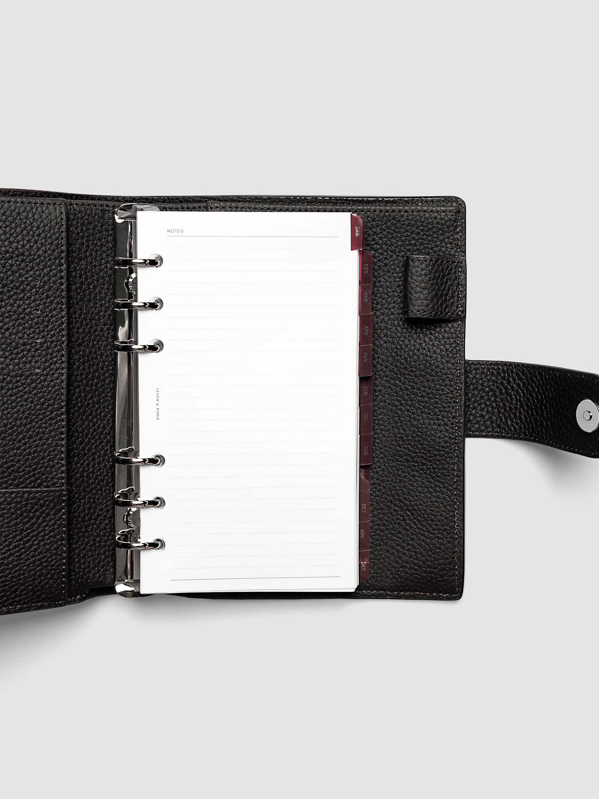 Personal 6-Ring Punch Ultra-Thin Monthly Dividers in deep red shown tabbed inside a planner