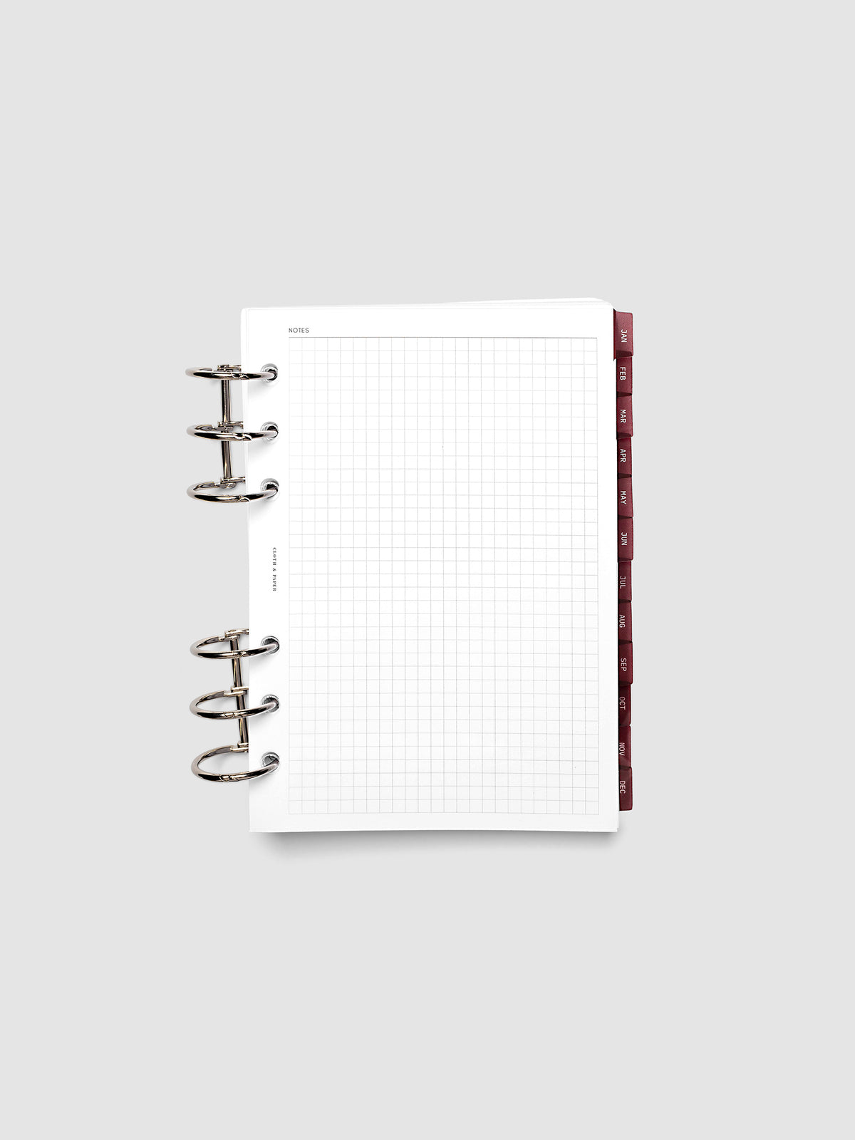Personal Wide 6-Ring Punch Ultra-Thin Monthly Dividers in deep red shown tabbed inside a planner