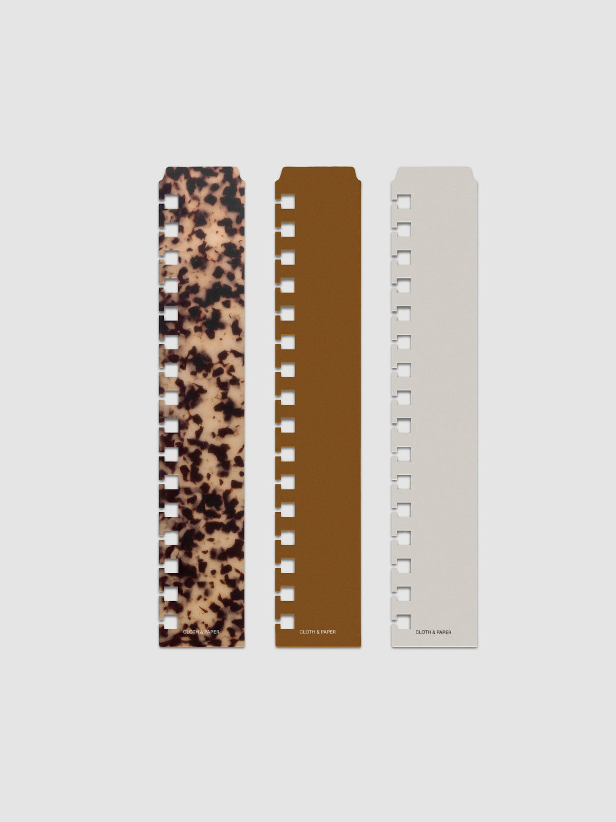 Narrow Page Marker Set Vol. 2, a set of 3 page markers for planners and notebooks shown in size A5 Spiral. Includes one tortoiseshell pattern, one solid brown, and one solid grey page marker.