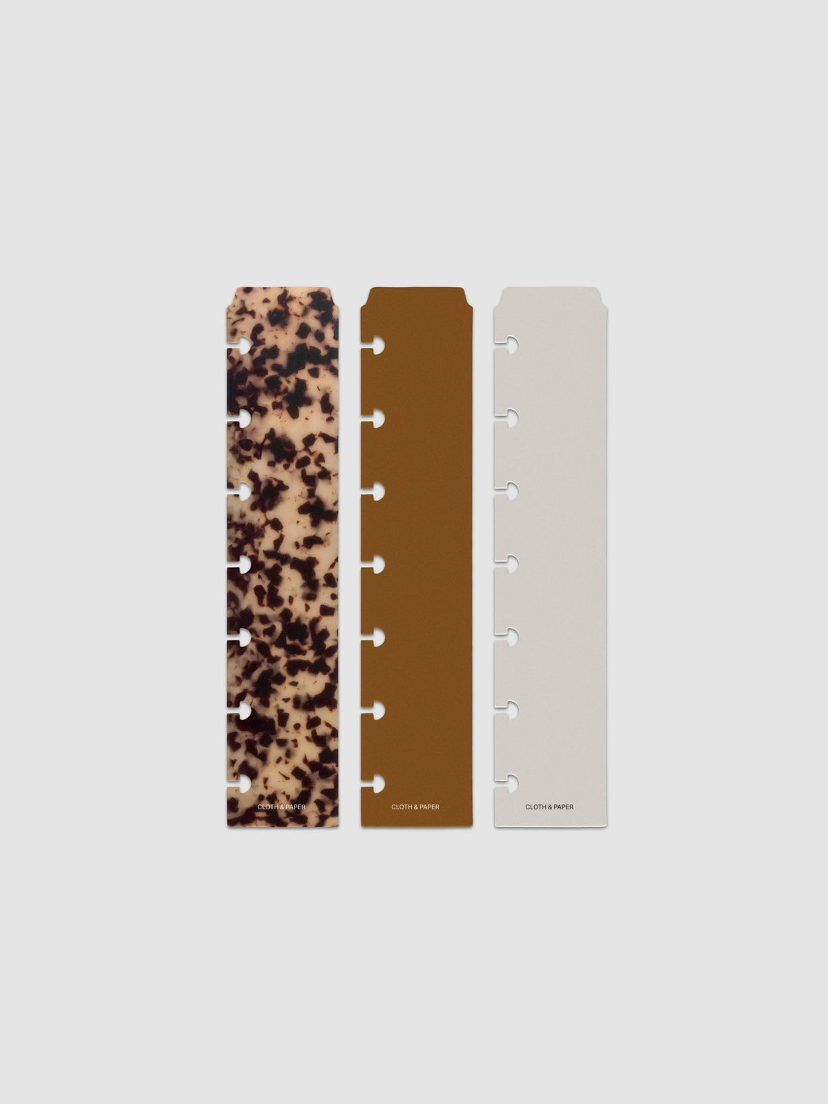 Narrow Page Marker Set Vol. 2, a set of 3 page markers for planners and notebooks shown in size HP Mini. Includes one tortoiseshell pattern, one solid brown, and one solid grey page marker.
