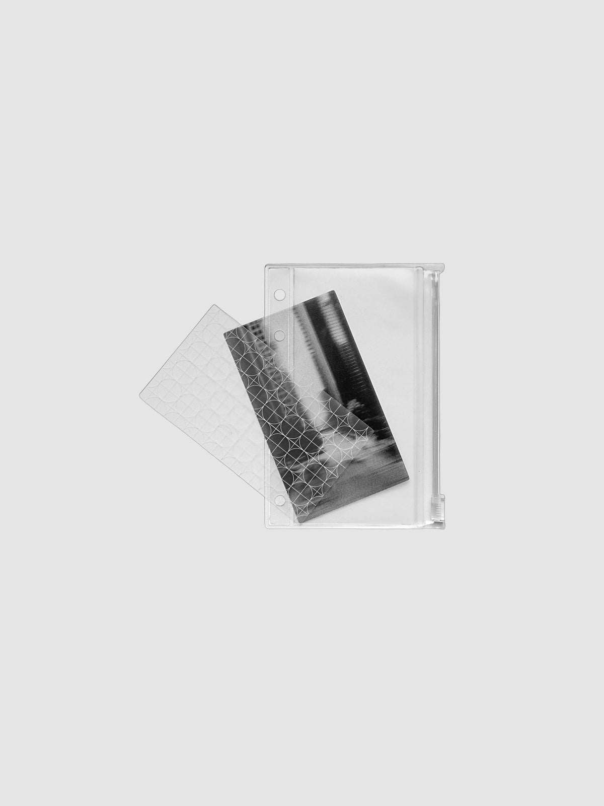 One transparent graph overlay, one black and clear abstract photo overlay, and one clear pre-punched zippered pouch for planners. Shown in size Pocket.