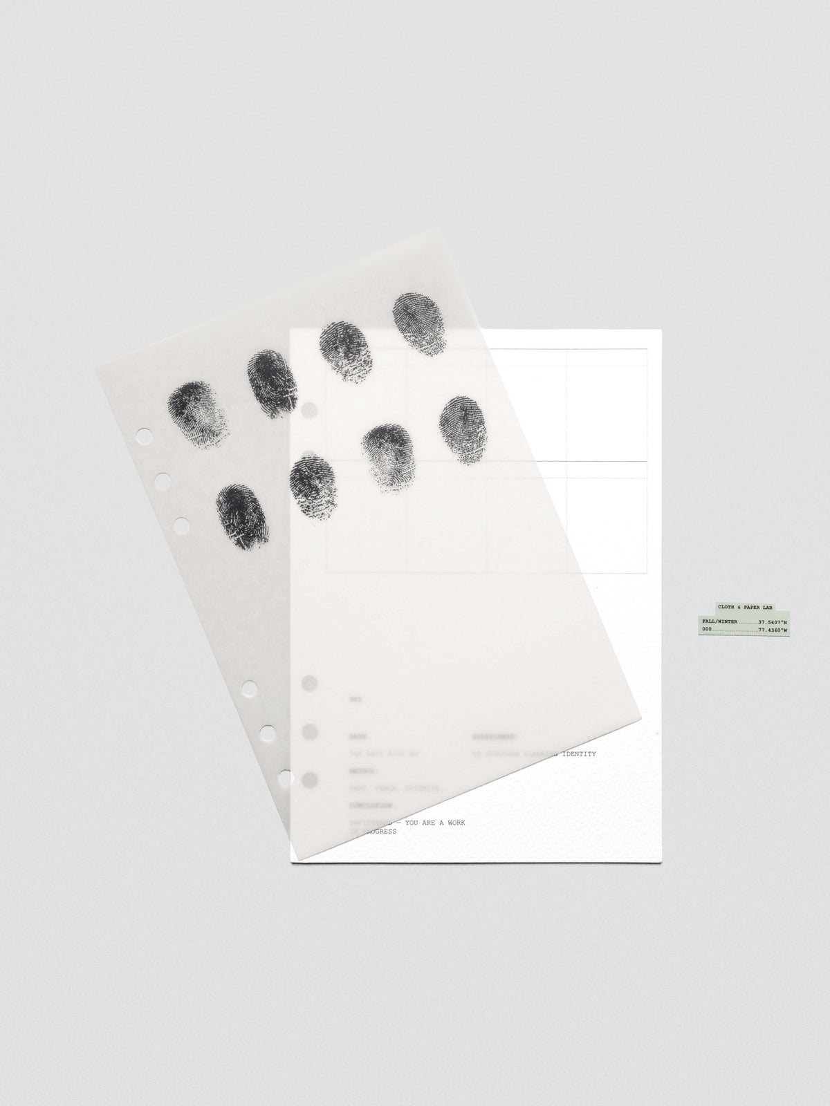Two layered A5 sized planner dashboards, one semi-transparent, one matte, featuring a fingerprint design shown offset from one another.