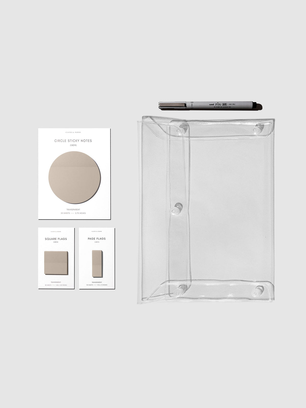 Matching set of circle sticky notes, page flags, and square page flags positioned next to a Uni Pin Marking Pen and Essentials Clear pouch. Sticky note color is Crepe.