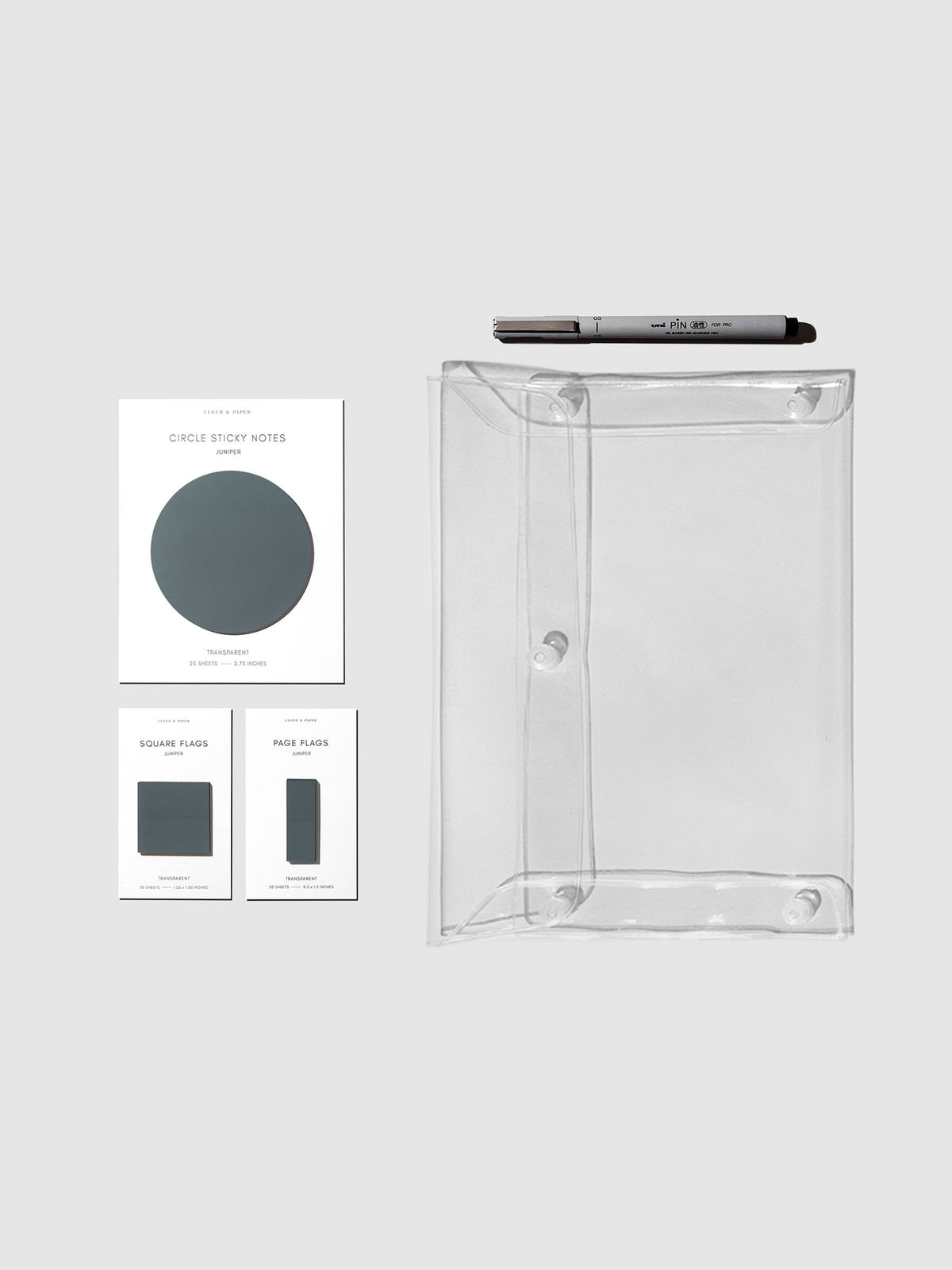 Matching set of circle sticky notes, page flags, and square page flags positioned next to a Uni Pin Marking Pen and Essentials Clear pouch. Sticky note color is Juniper.