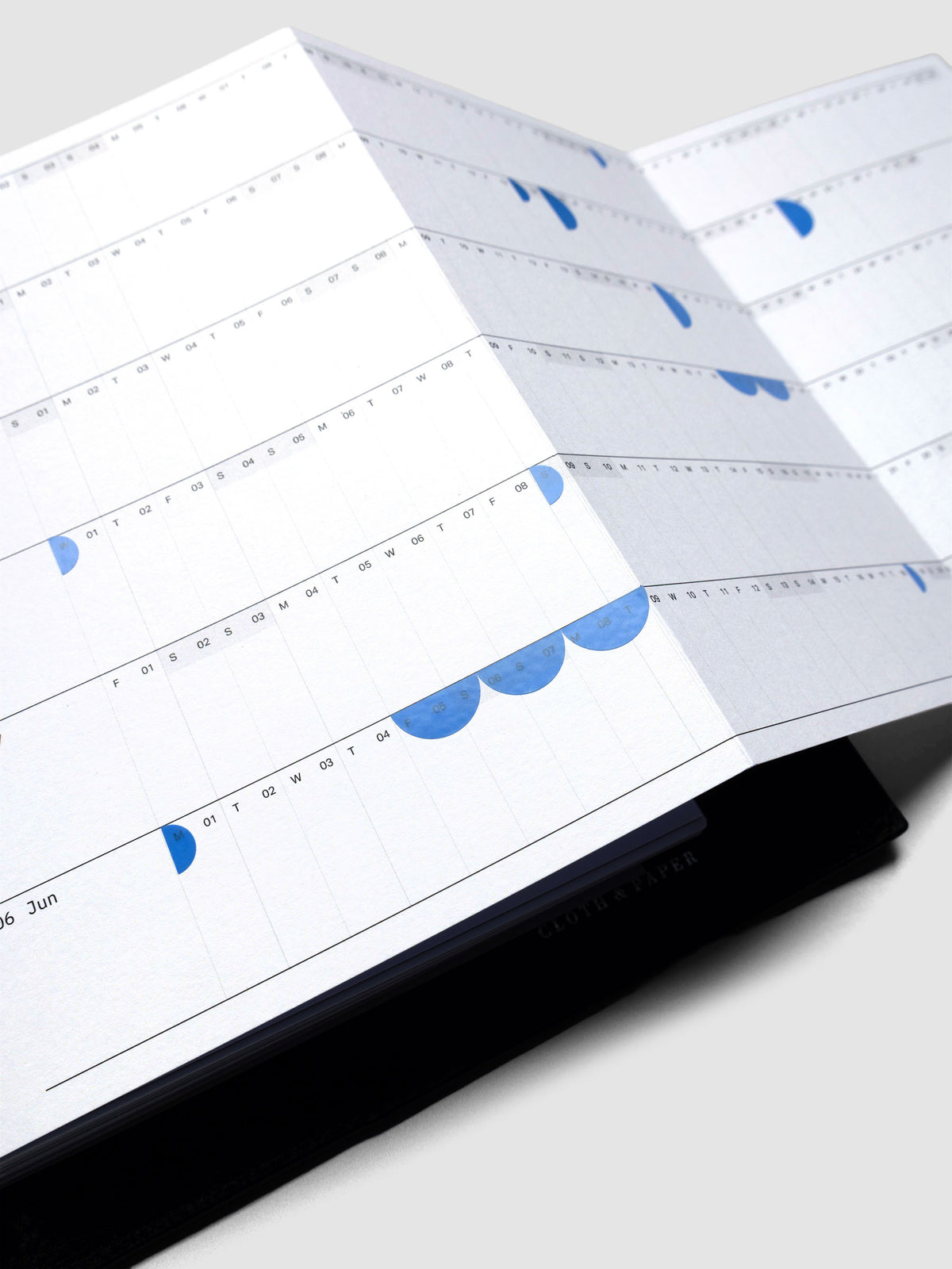 2026 Yearly Fold Out Planner Insert in size A5 shown un-folded, in use, in a black leather agenda cover.