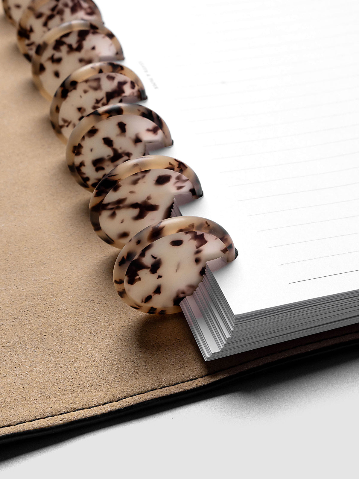 1.25" Inch Desert Tortoiseshell Planner Discs shown in use as binding with planner inserts.