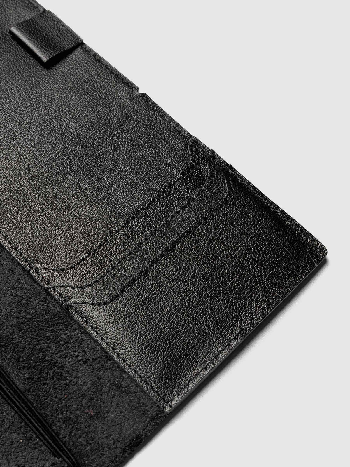 Black leather travel notebook cover in size A5 Slim shown open with interior pockes and elastic bands.
