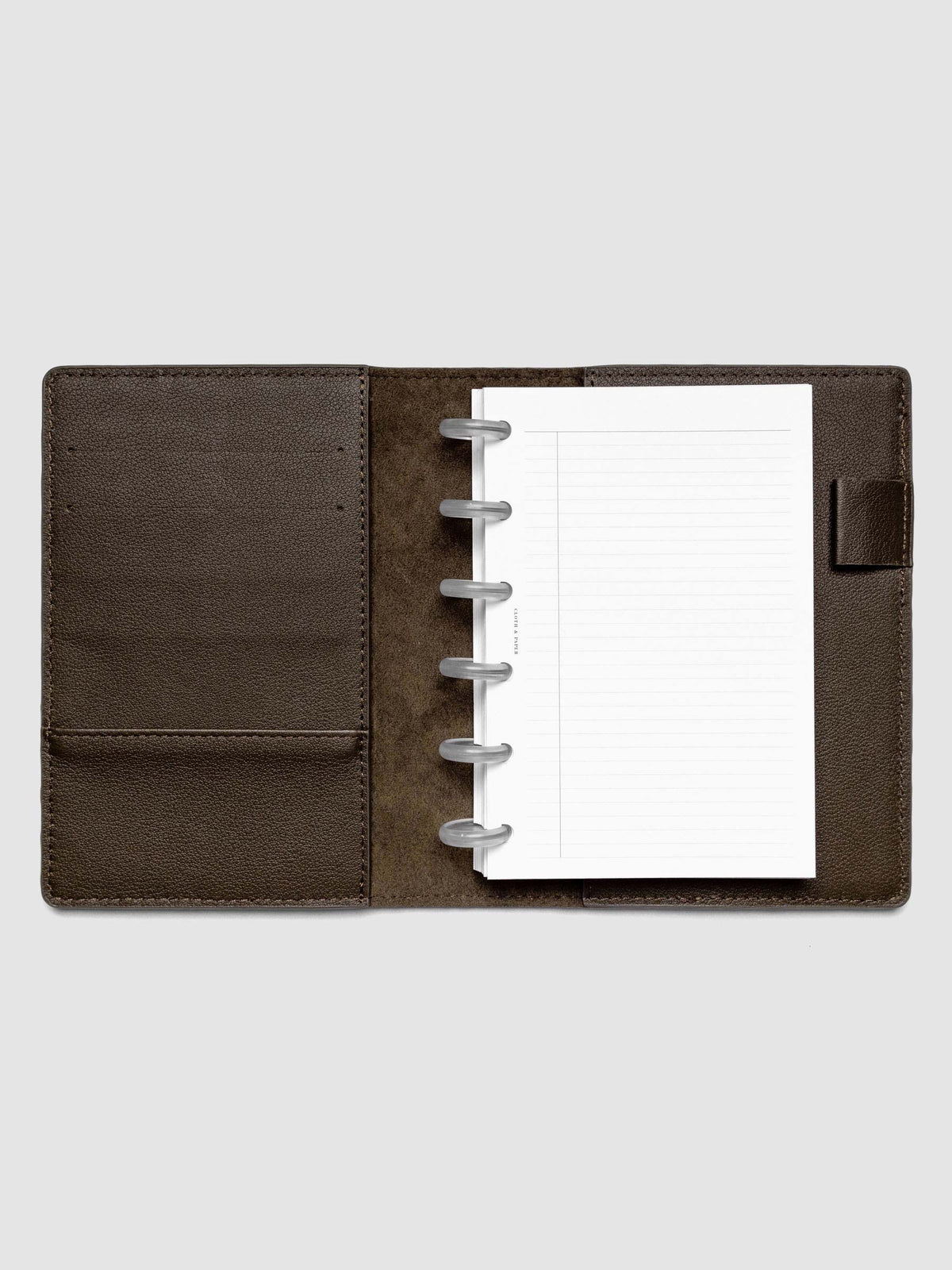 Open dark brown leather planner folio with a CP petite discbound planner inside.