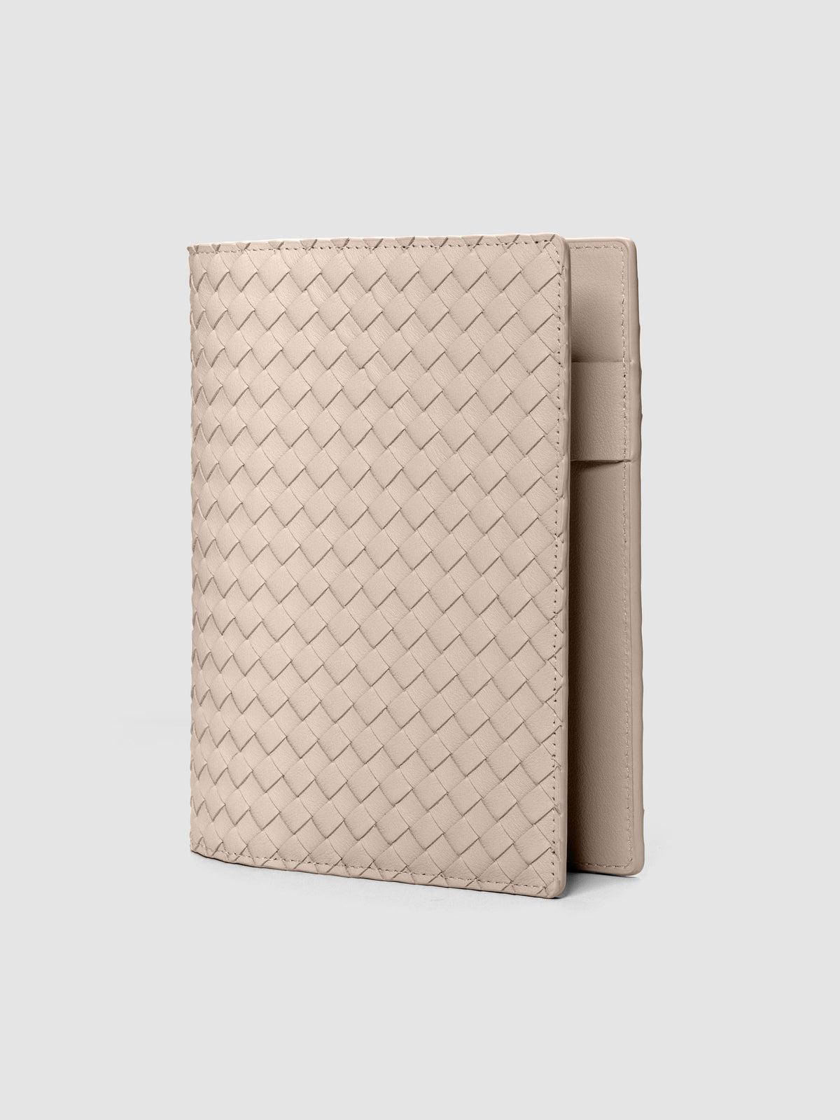 Beige woven leather planner cover shown standing at an angle.