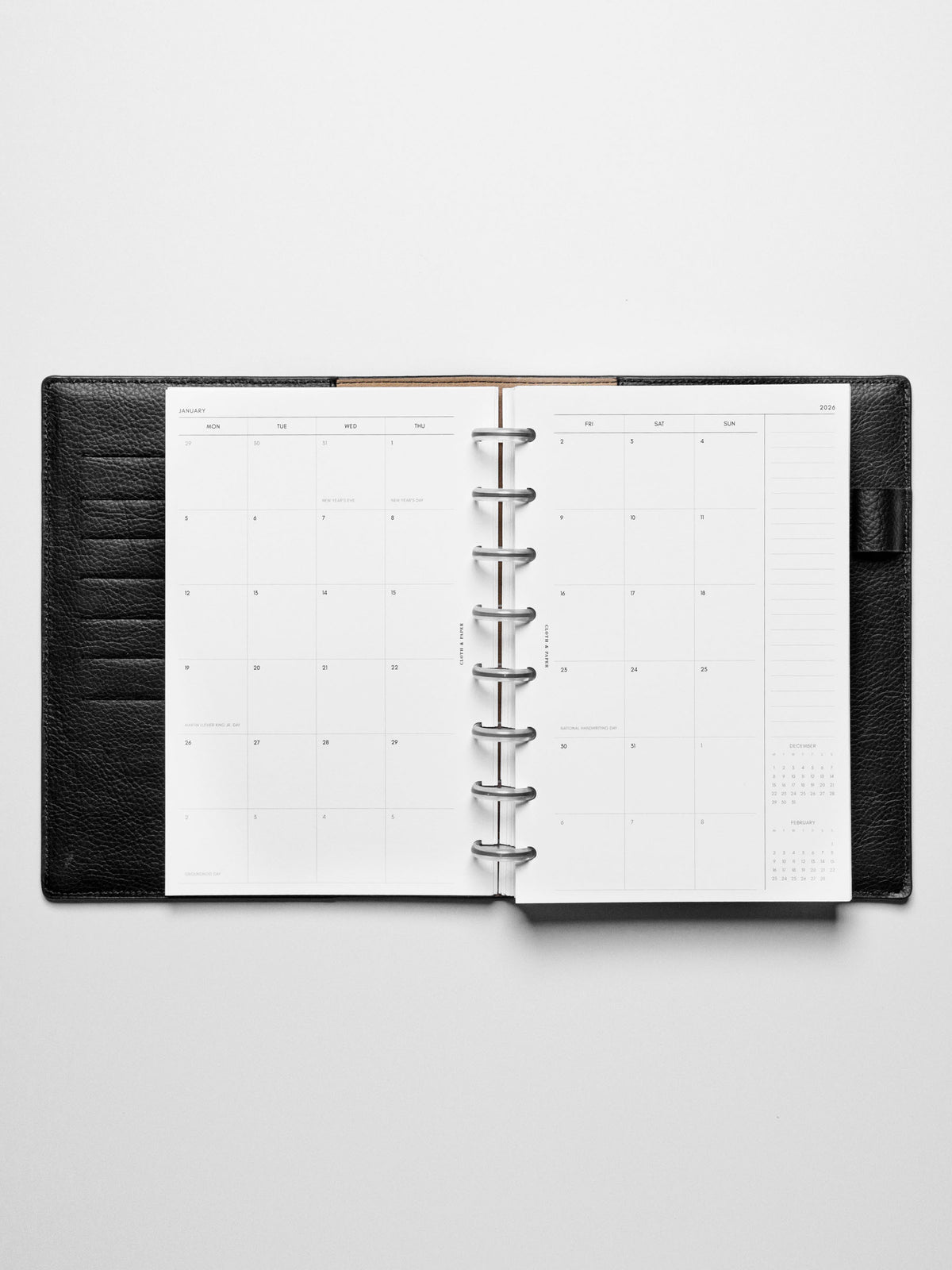 Image shows the Monday Start 2026 Dated Monthly Planner Inserts used in a black leather Half Letter disc-bound planner.