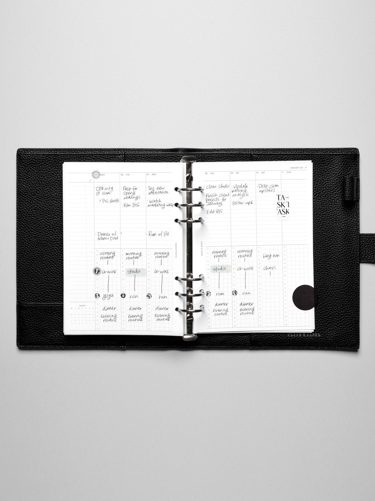 Image shows the Monday Start 2026 Dated Weekly Schedule Planner Inserts in a black leather ring-bound planner.