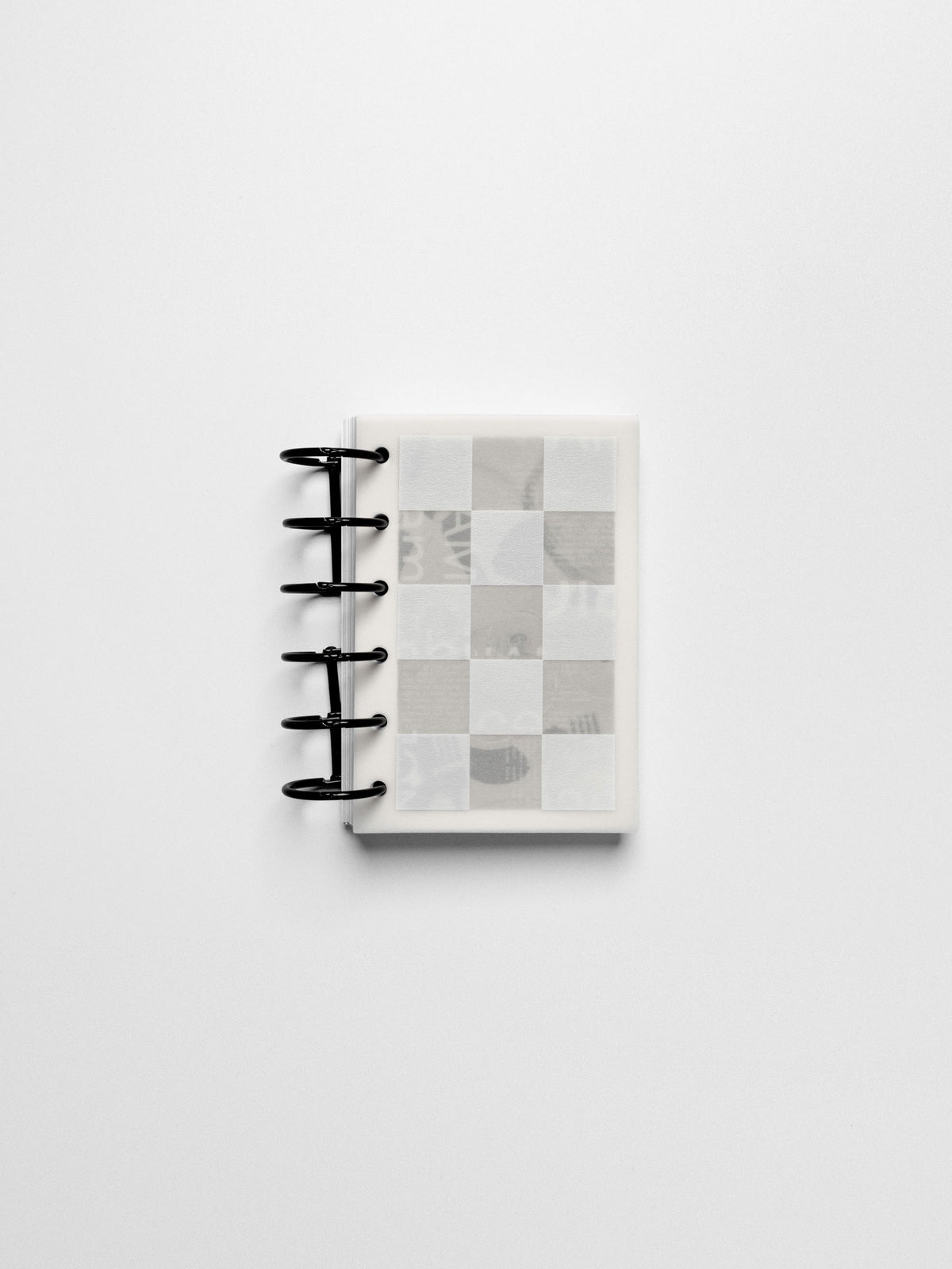 Ambiance Dashboard Trio assembled inside a compact Pocket sized ring-bound planner with black rings showing the grid layer on top.