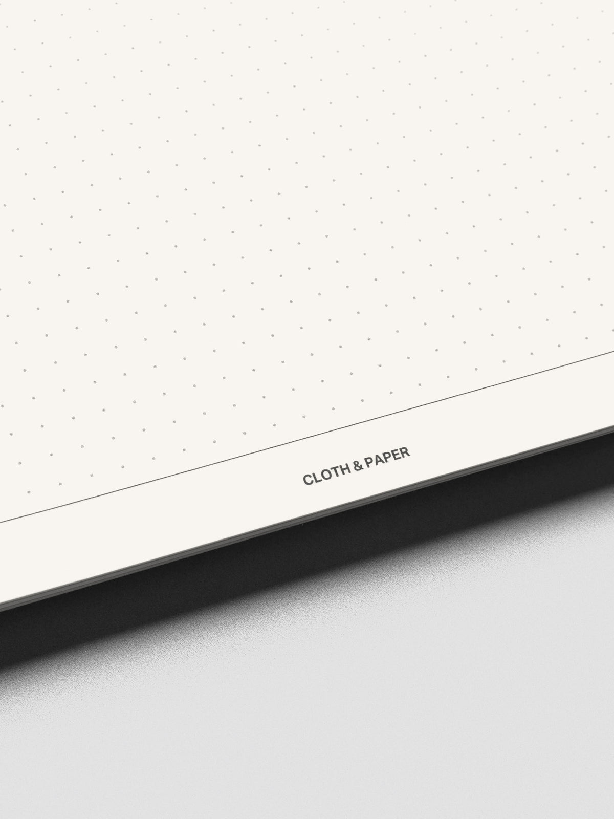 Close up view of the bottom of the Break Room notebook pages showing dot grid style and the Cloth & Paper logo.