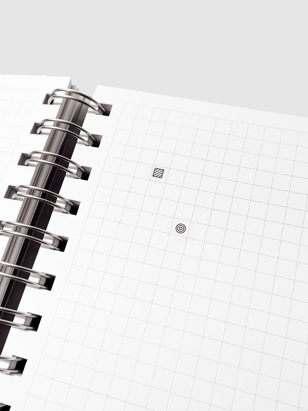 Two Bujo stickers shown in a grid notebook. One is a square design, the other a circle.