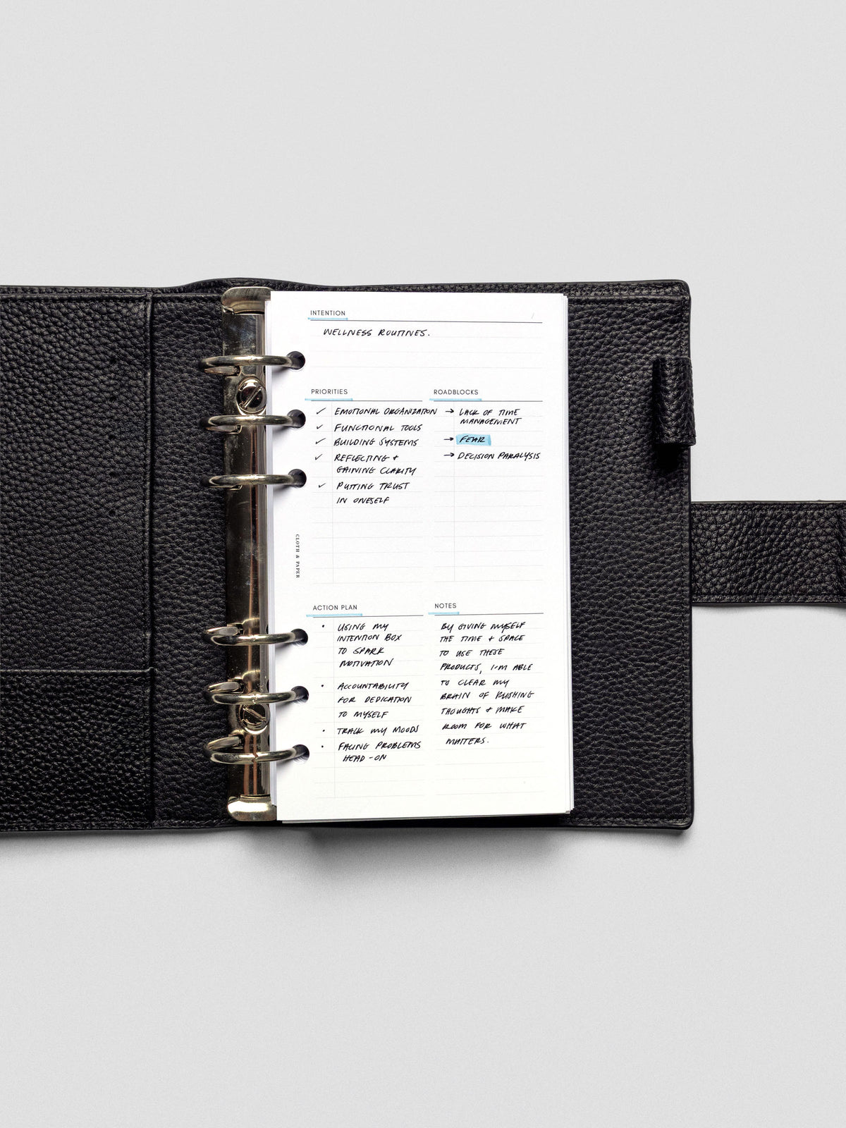 Daily Intention Planner Inserts show filled out in Personal size ring bound in a leather cover.