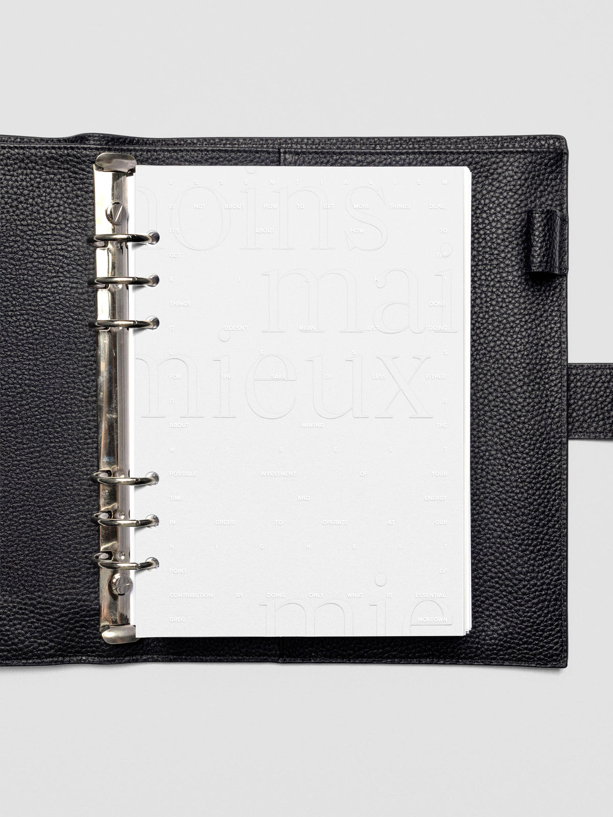 Essentialism Dashboard Duo reading "moins mai mieux" in size A5 shown in leather agenda.