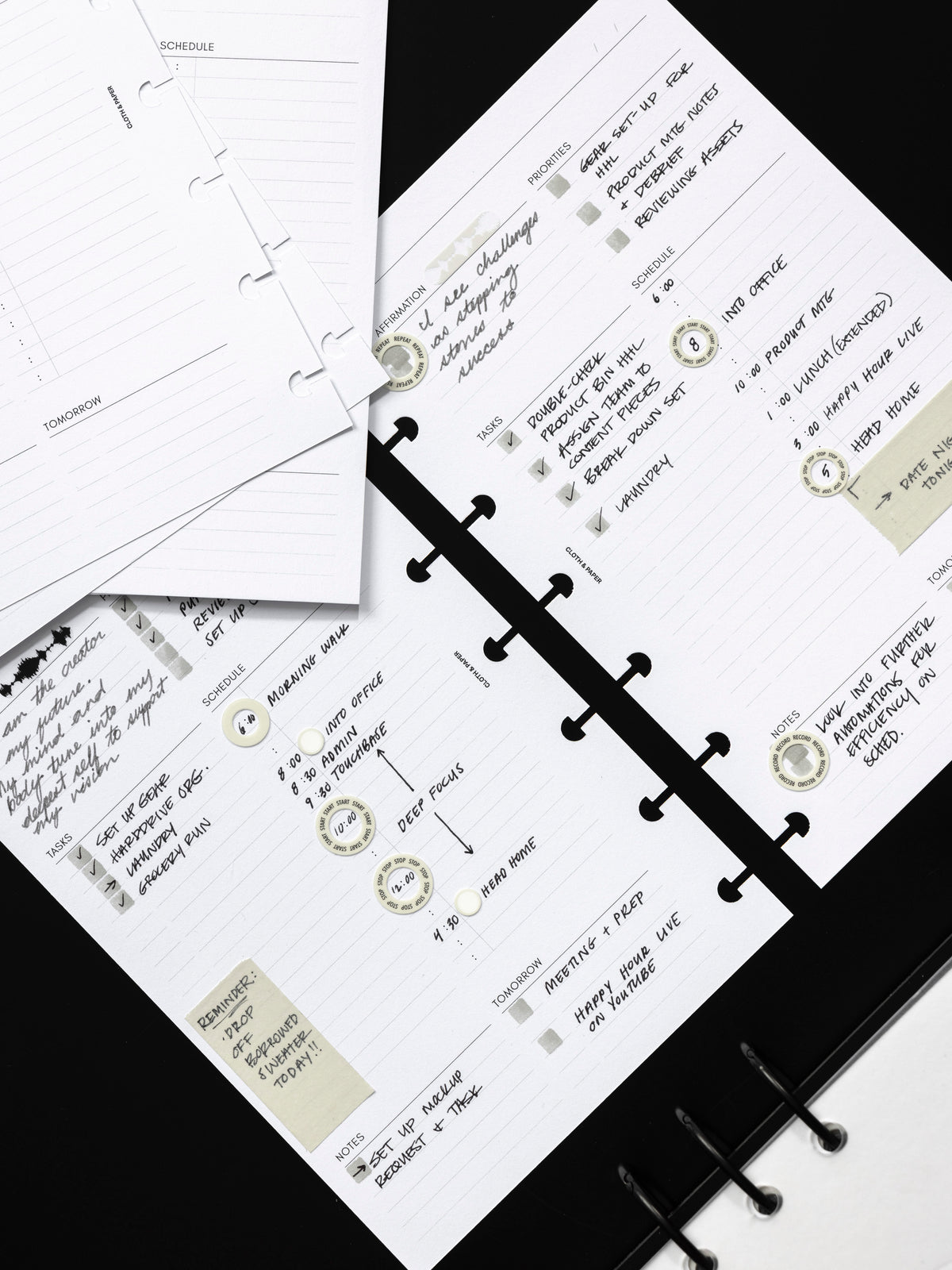 Daily Essentials Planner Inserts shown in use with handwritten notes and decorative stickers.