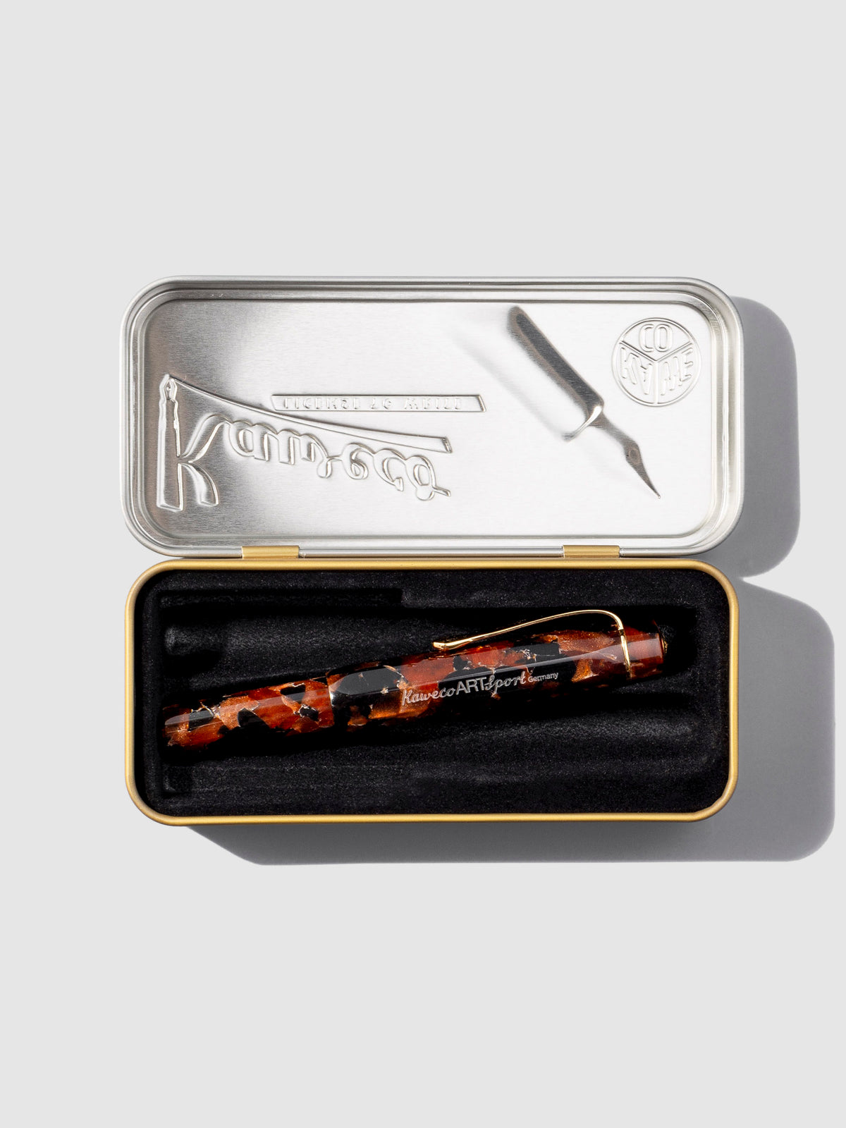 Pen displayed inside its gold and silver colored storage case. It is laying in a black felt liner.