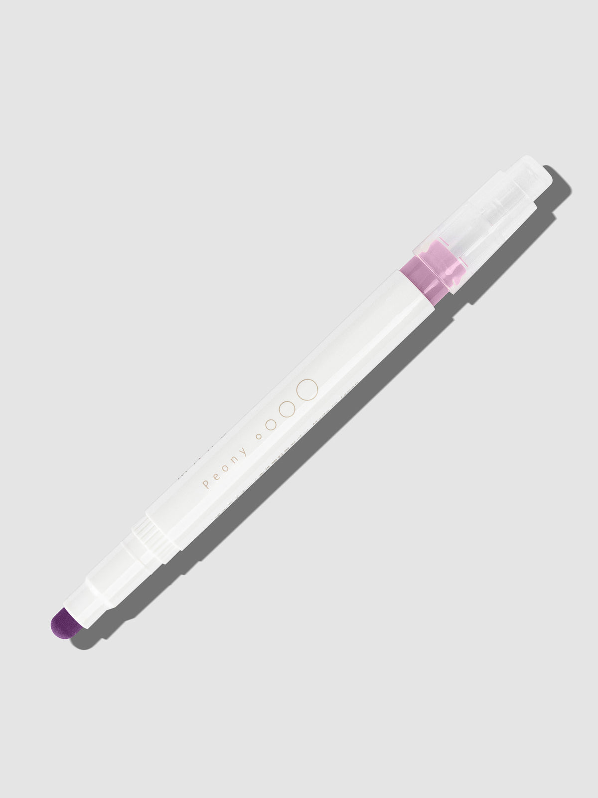 Peony highlighter with tip exposed and cap posted to the end of its barrel on a neutral background.