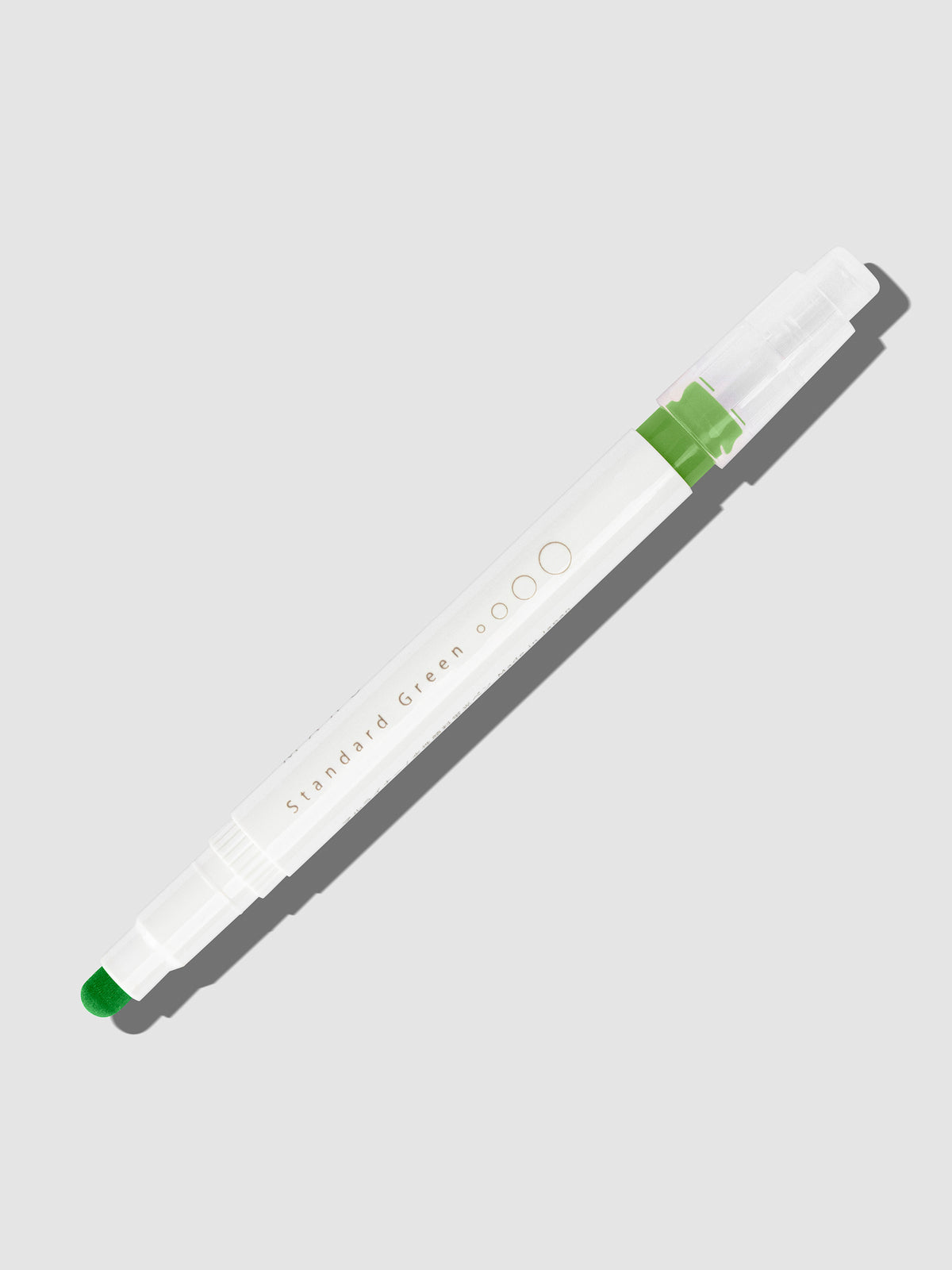 Standard Green highlighter with tip exposed and cap posted to the end of its barrel on a neutral background.