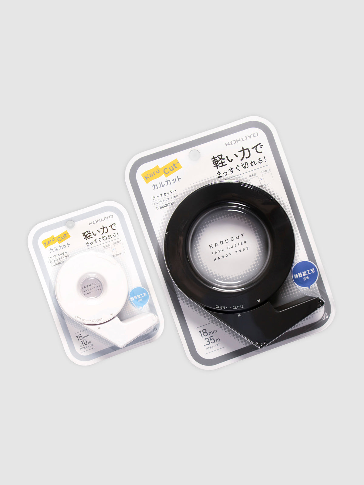 Kokuyo Karu Cut Tape Cutter, Large and Small, Cloth and Paper. Tape cutters of two sizes in their packaging, parallel to each other, turned slightly to the left against a neutral background.