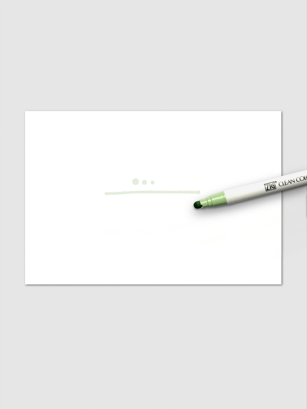 Pale Moss marker shown in use with light green dots and a fine line drawn on a white paper background.