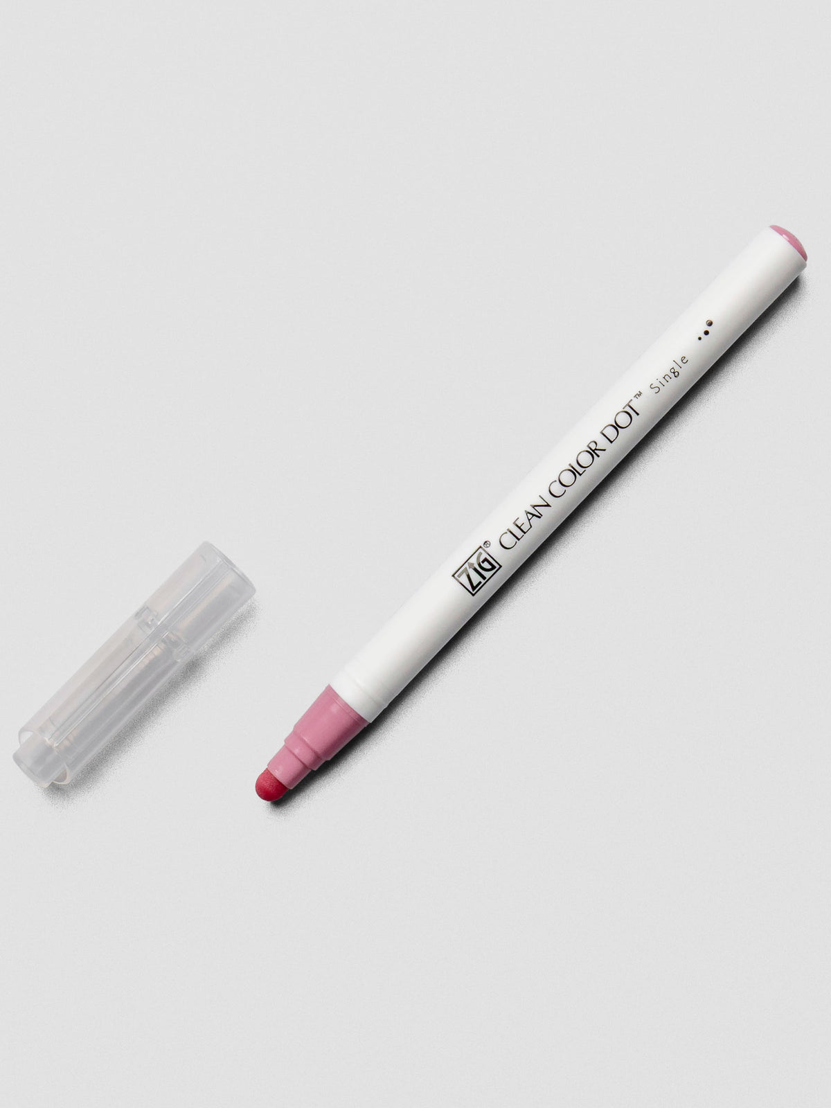 A Kuretake ZIG Clean Color Dot Marker in Pale Rose with the cap removed, showing the soft rounded dot tip and minimal white barrel design.