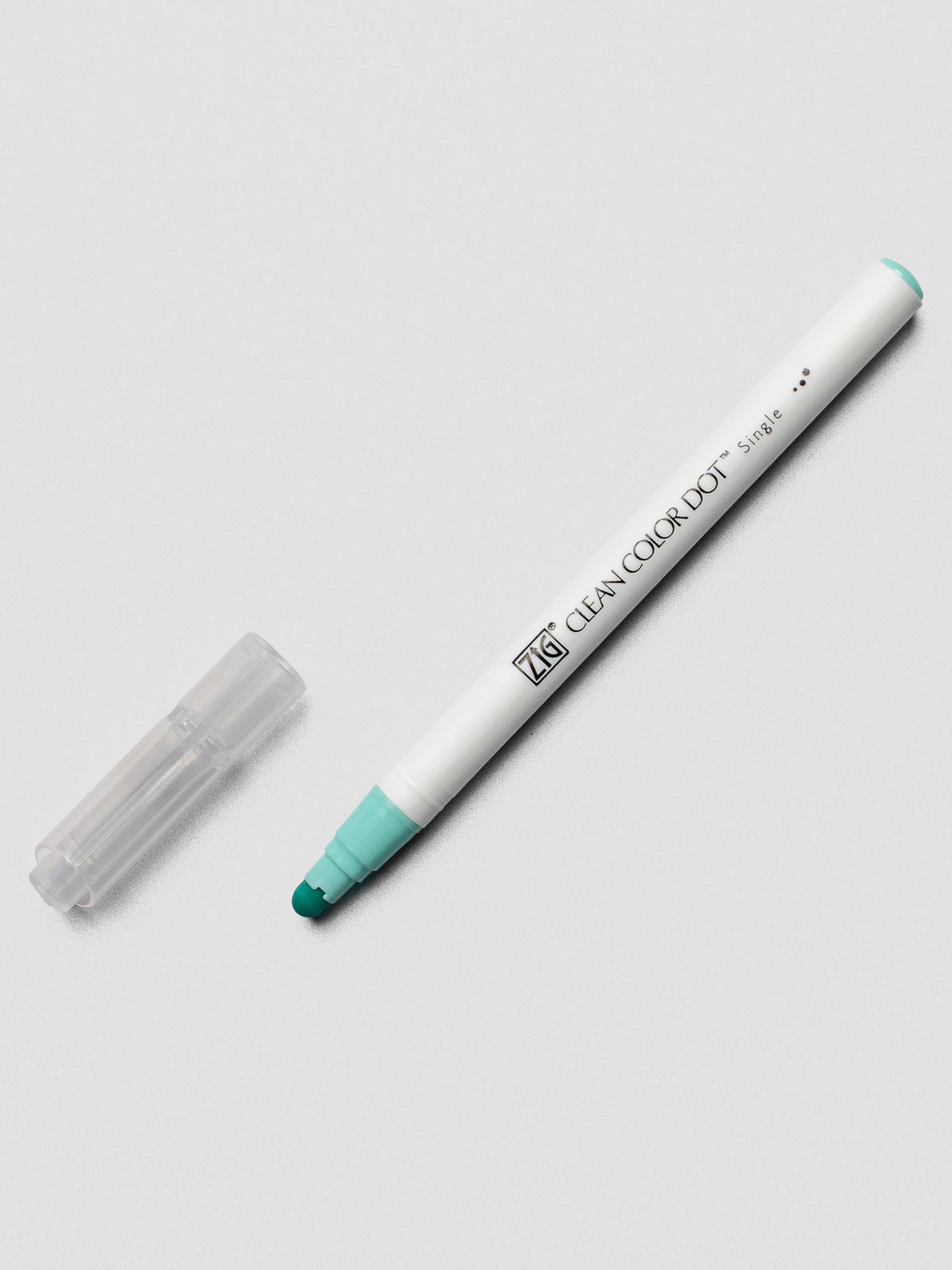 A Kuretake ZIG Clean Color Dot Marker in Pale Turquoise, uncapped to show the flexible dot tip and its signature white plastic body.