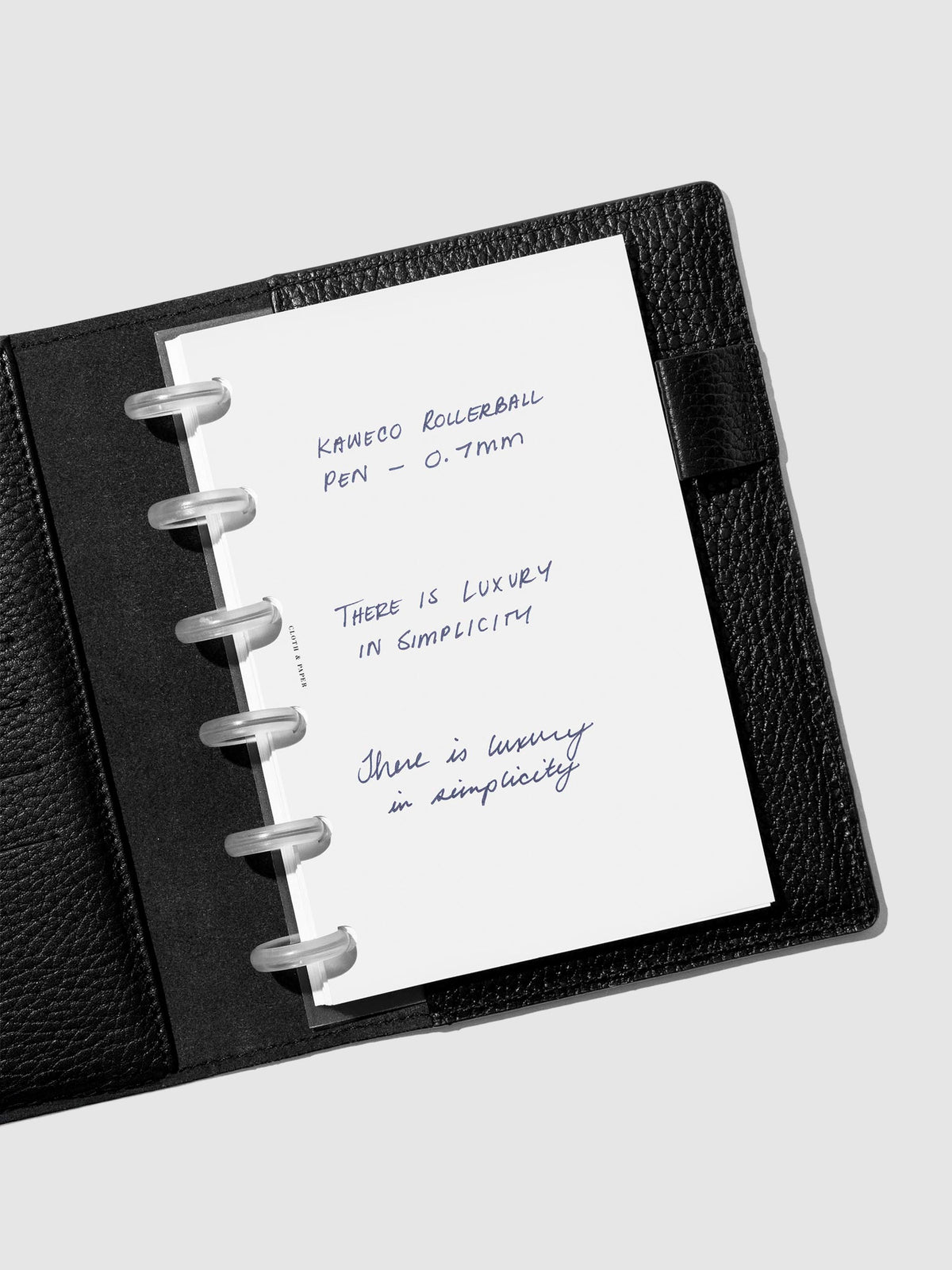 Writing sample shown in a black leather folio.