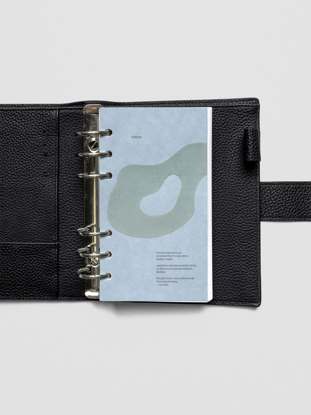 Blue speckle cardstock planner dashboard with organic shape design flocked in blue-green with text design shown in Personal size in a ring bound leather cover.