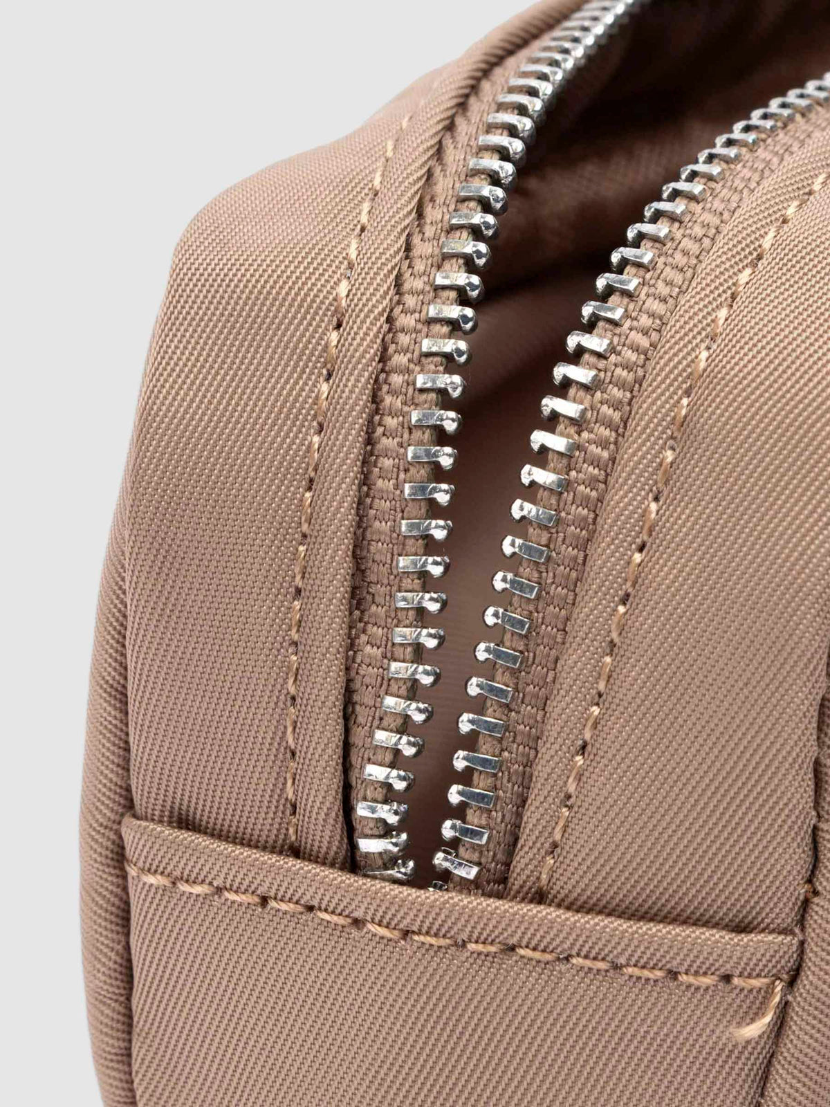 Closeup of pencil pouch's zipper. Color featured is fossil.