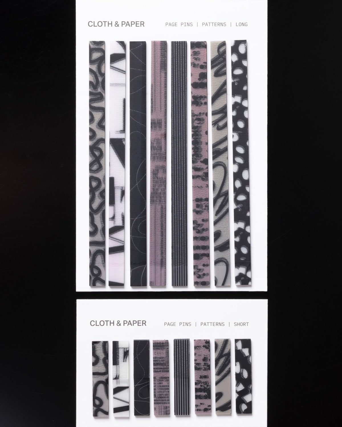 Flat lay of Cloth & Paper Page Pins in both Long and Short styles, with abstract and minimalist patterns.