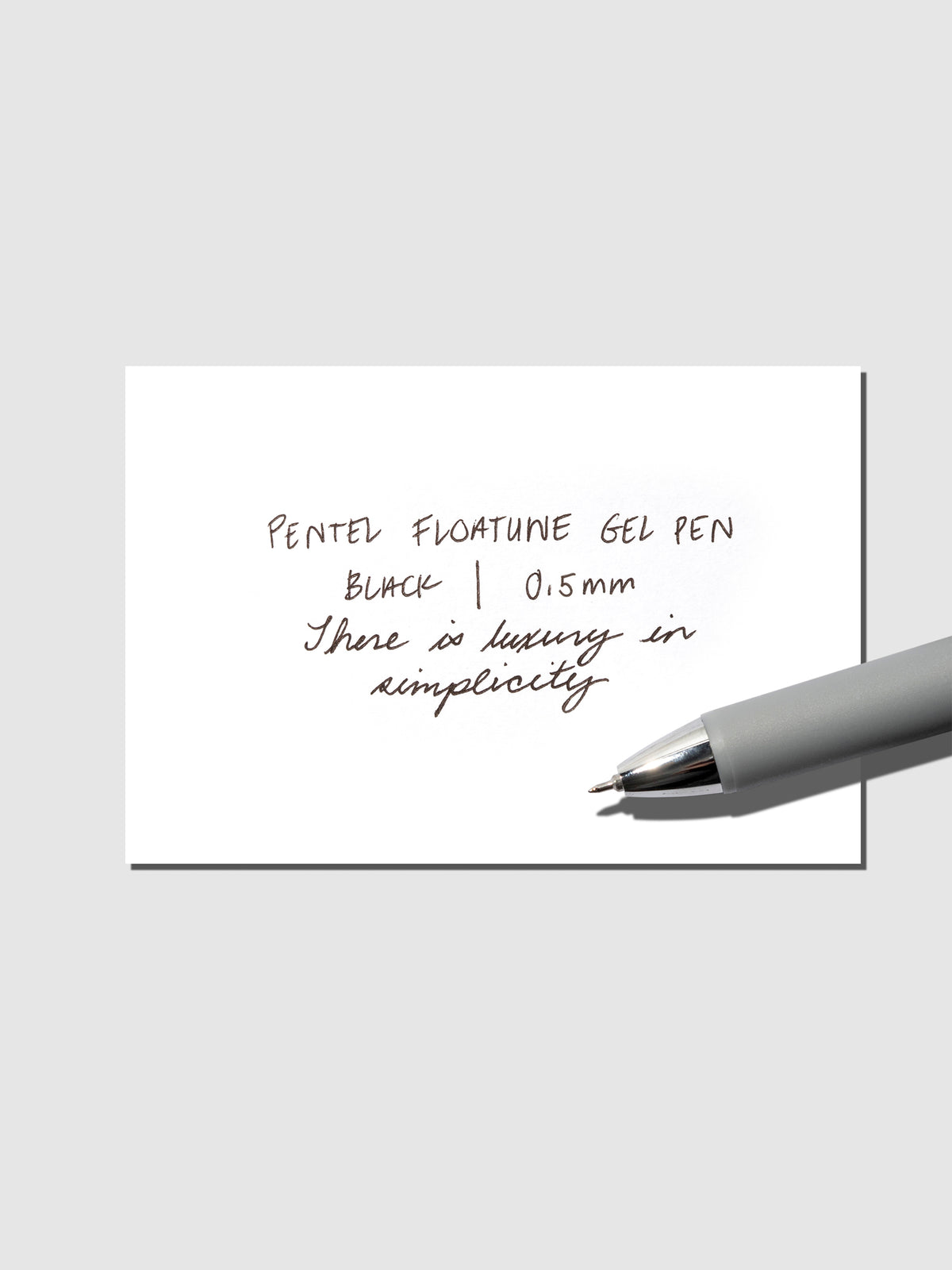 Pentel Floatune Gel Pen 0.5mm black ink. Pen resting on pen test sheet displaying writing sample.