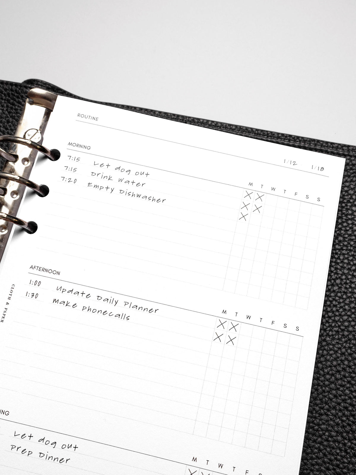 Closeup of insert in use inside a black discbound planner system. Focus is on the morning and afternoon sections of the routine section.