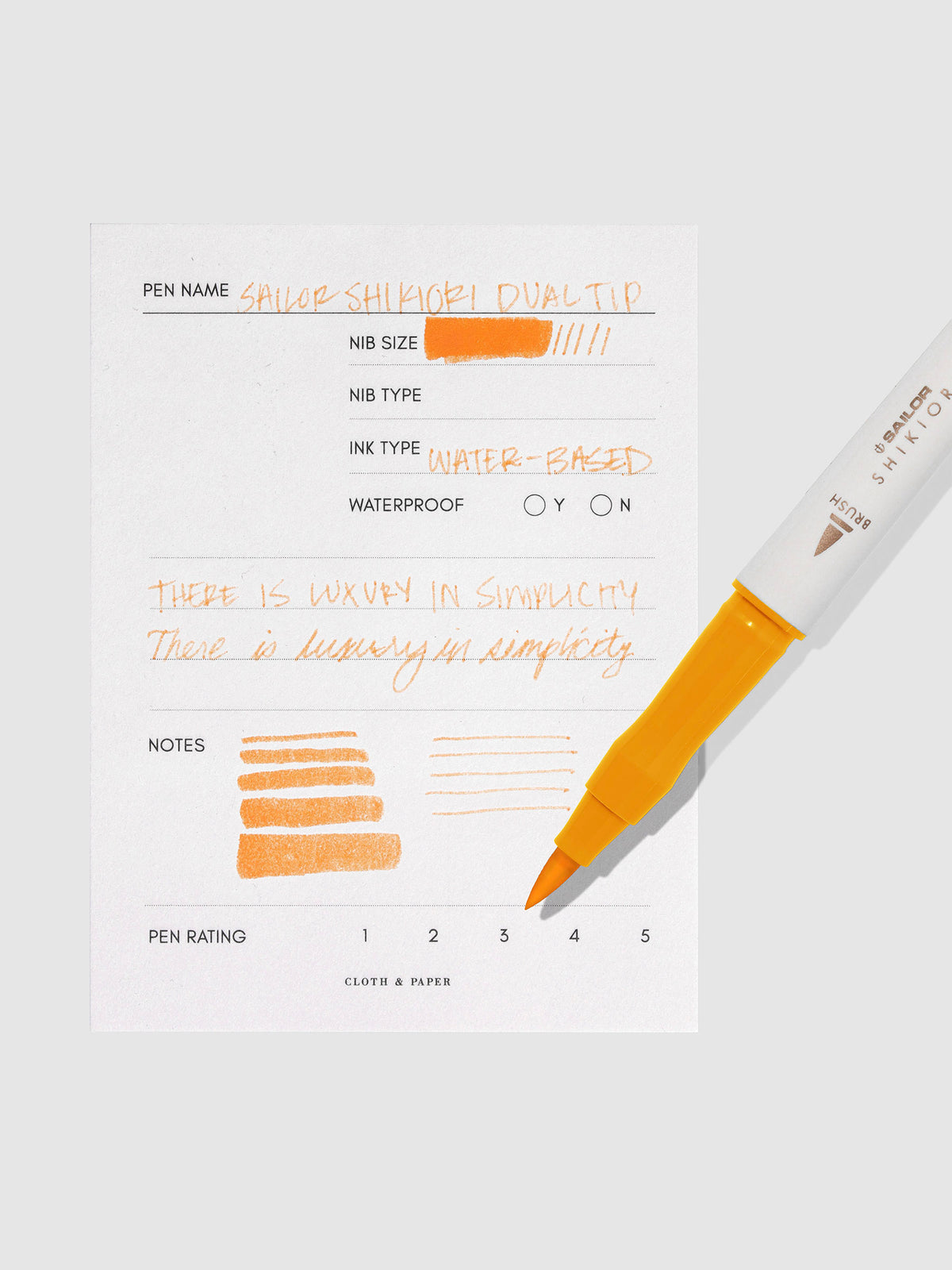 Pen displayed next to in use pen test sheet. Color pictured is Kinmokusei.