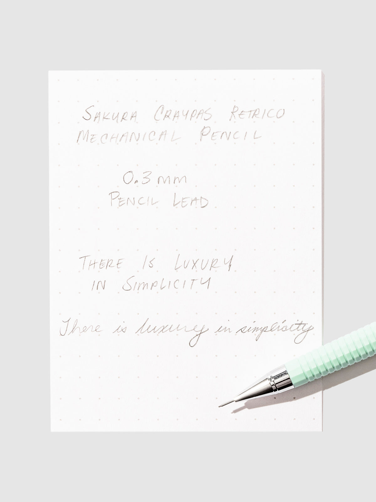 Writing sample with pencil displayed on a neutral background.