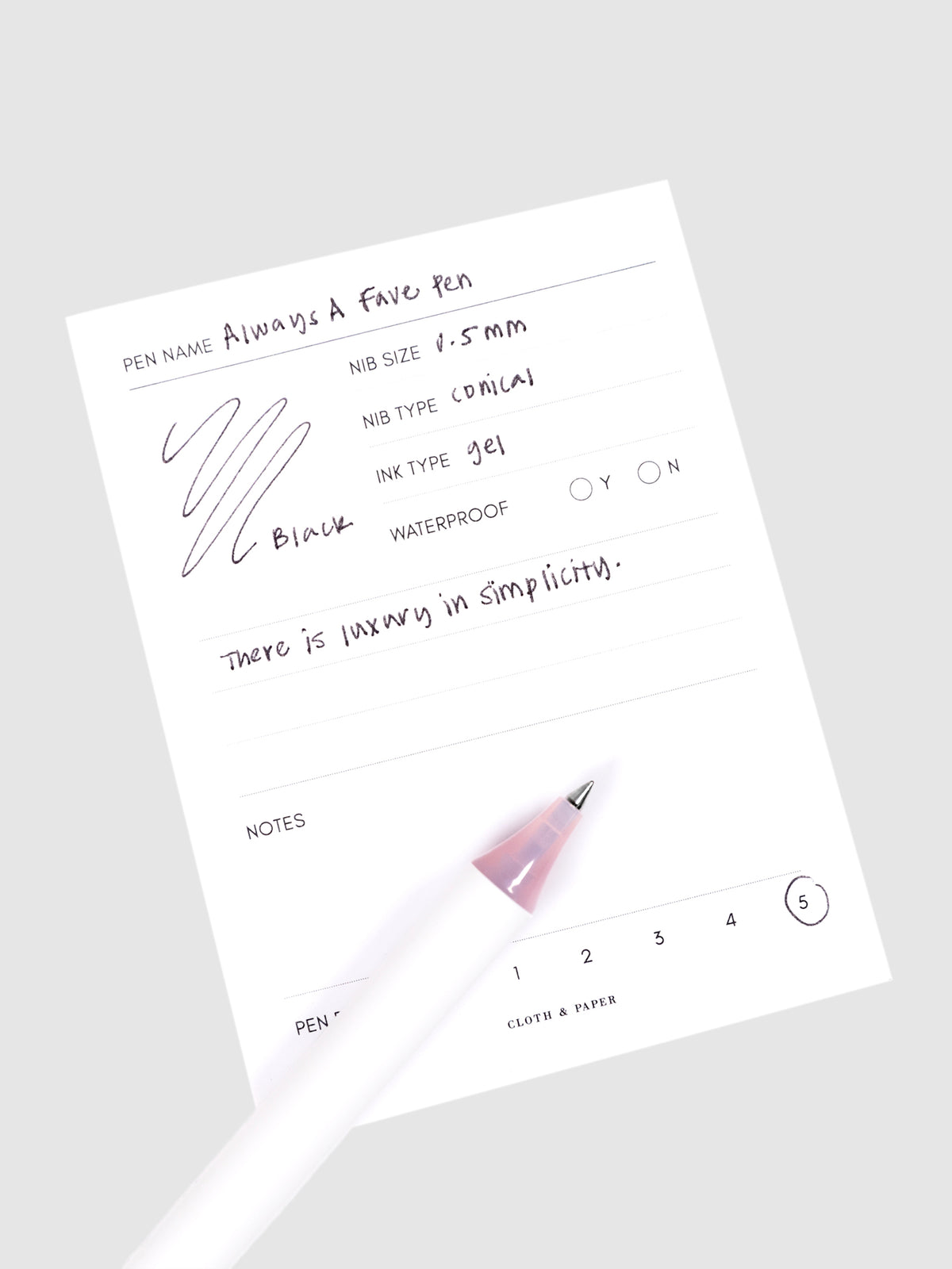 Always a Fave Pen, Pink, Cloth and Paper. Pen resting on pen test sheet displaying writing sample.