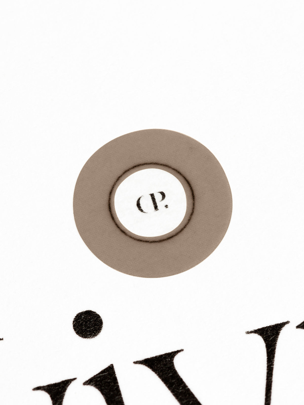 Small sticker in use, placed over the Cloth and Paper logo on a sheet of paper.
