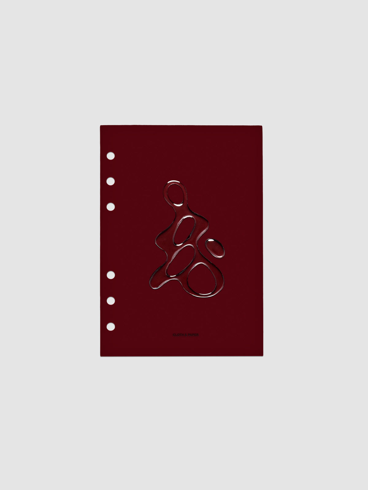 Dark red, semi-transparent, and glossy plastic planner dashboard with organic raised shape design in size Personal Wide on a neutral background.