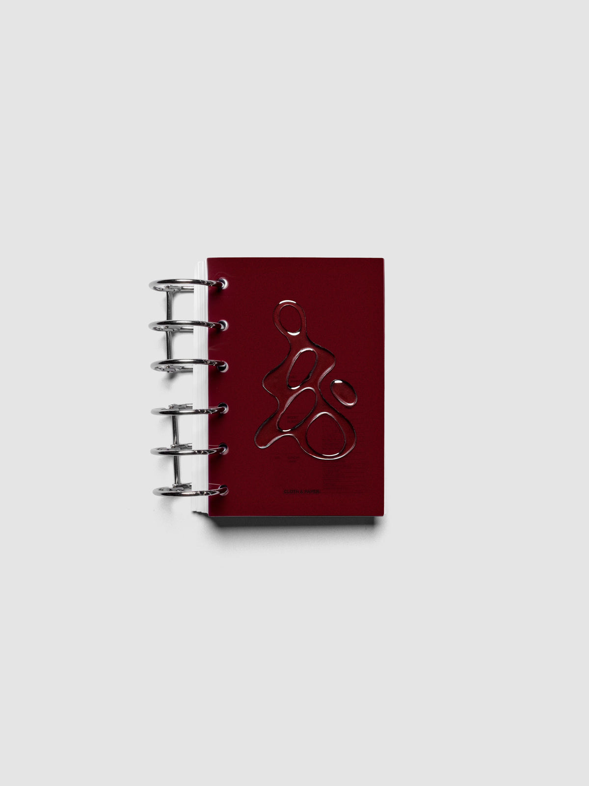 Dark red, semi-transparent, and glossy plastic planner dashboard with organic raised shape design in size Pocket shown ringbound.