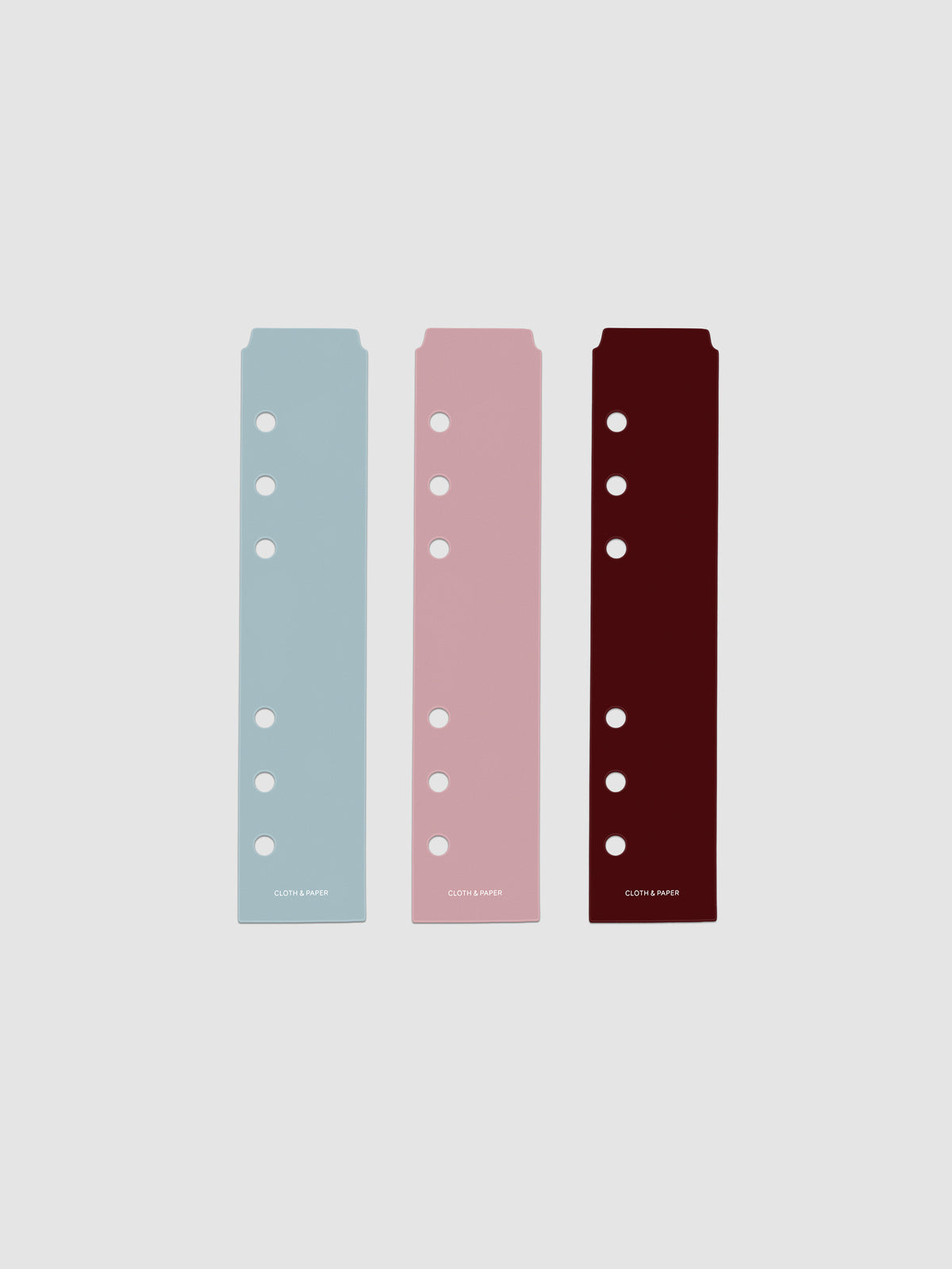 Set of three narrow page markers pre-punched for Personal and Personal Wide planners in light blue, pink, and burgundy on a neutral background.