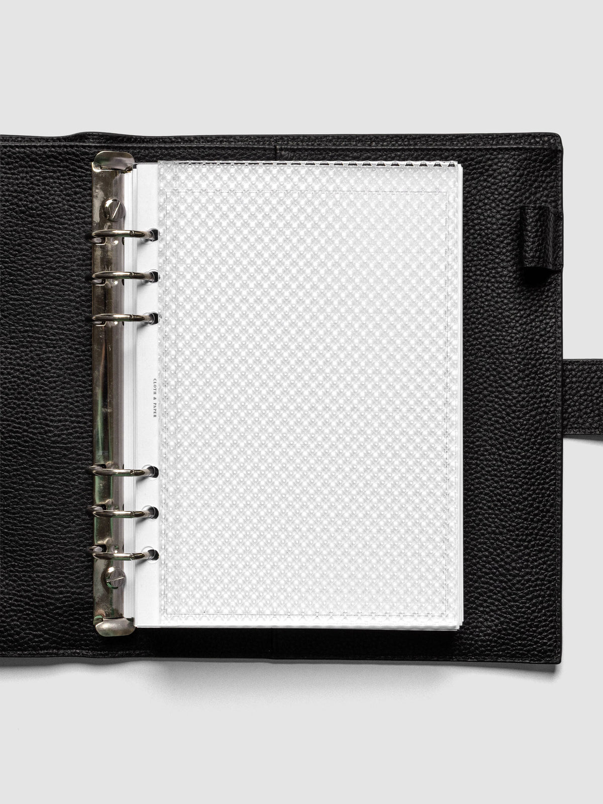 Clear, textured Studded Planner Dashboard in the size A5, shown ringbound in a black leather agenda.